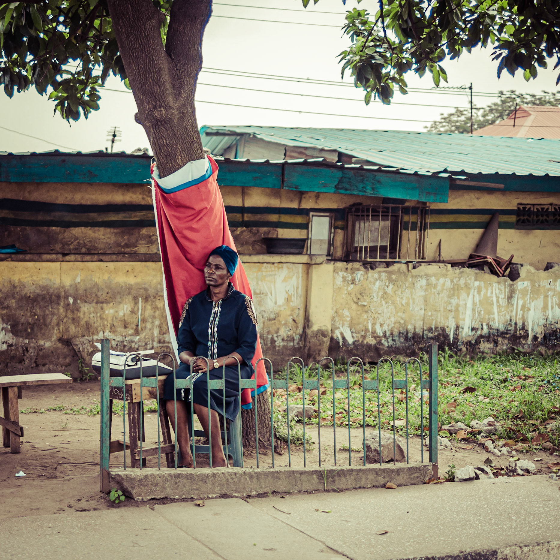 A typist in Lagos, Nigeria waits on the kerb-side for any passing business from the nearby court-house