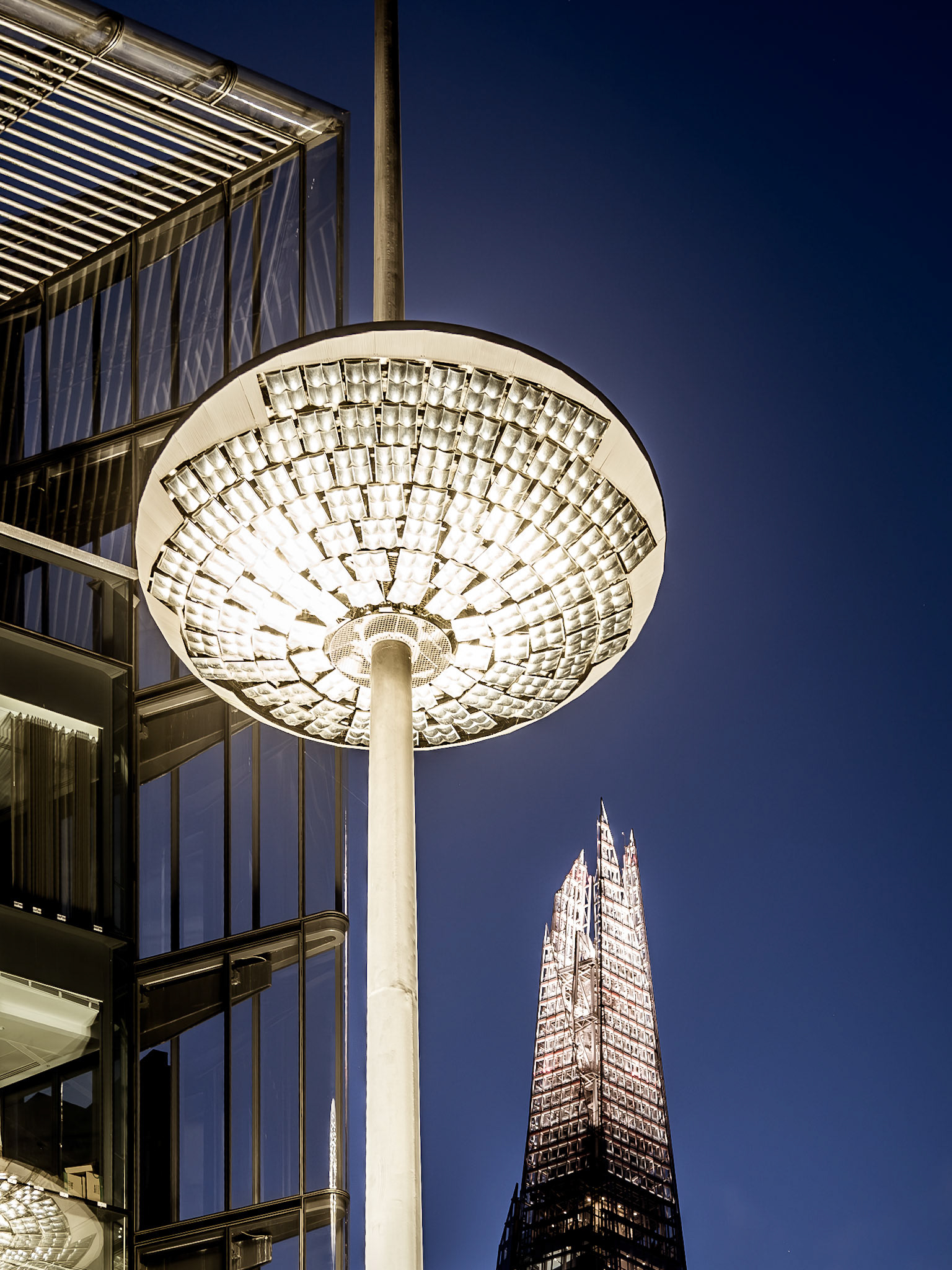 The top of the Shard in London sits behind a contemporary light installation near the River Thames