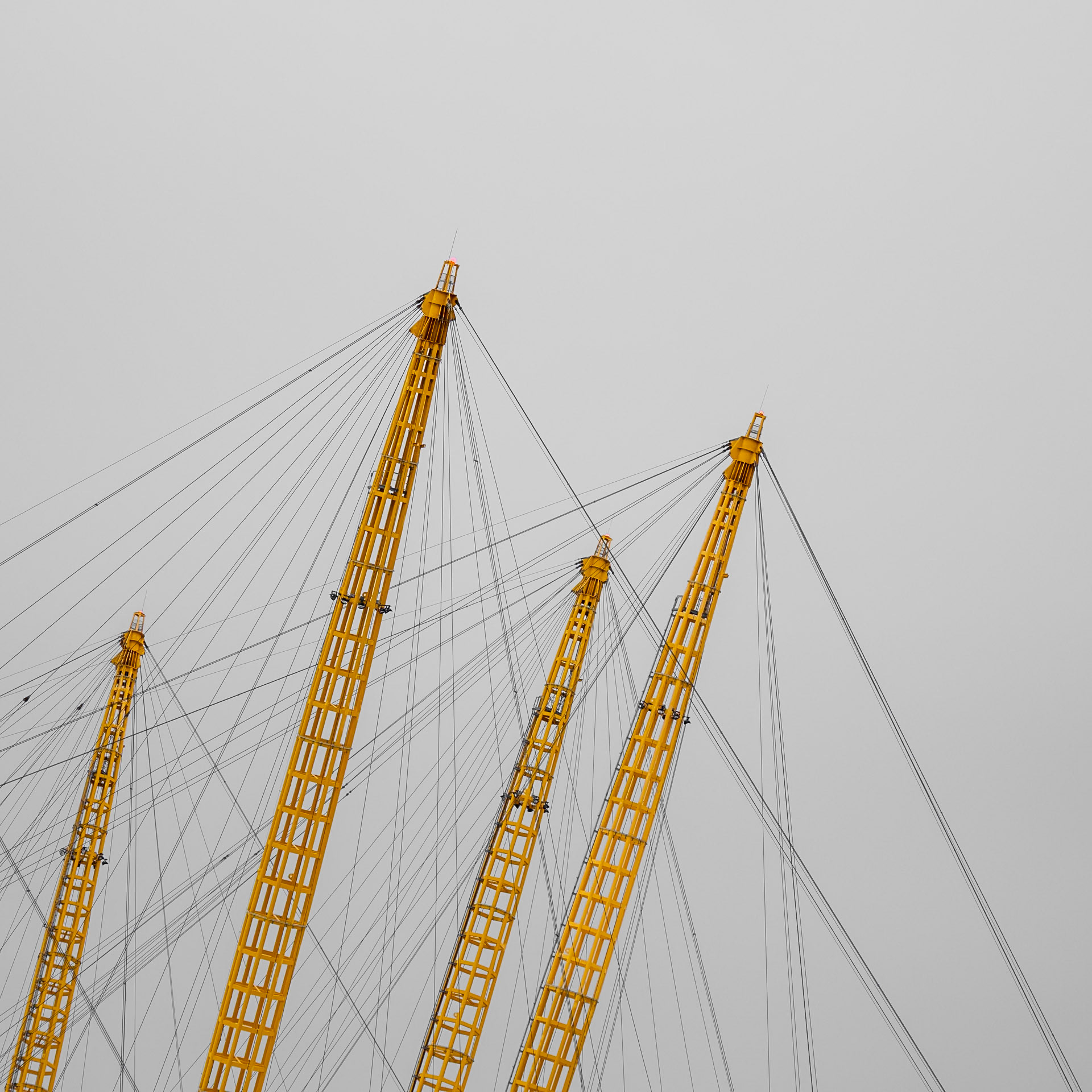 Bright yellow pylons of the O2 arena just into a cloudy sky over London
