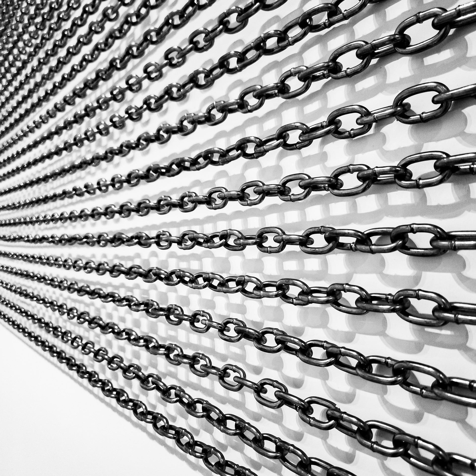 Links of chain cast shadows against a wall as part of contemporary art exihibit