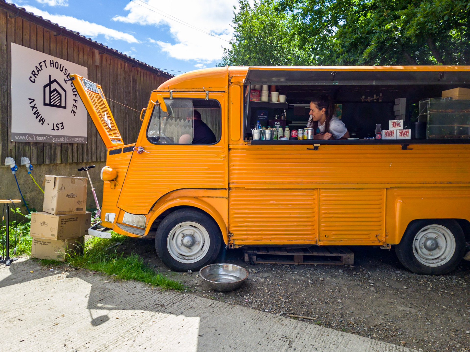 A woman looks on encouragingly as a colleague tries to restart a Citroen van after a summer of use as a coffee van