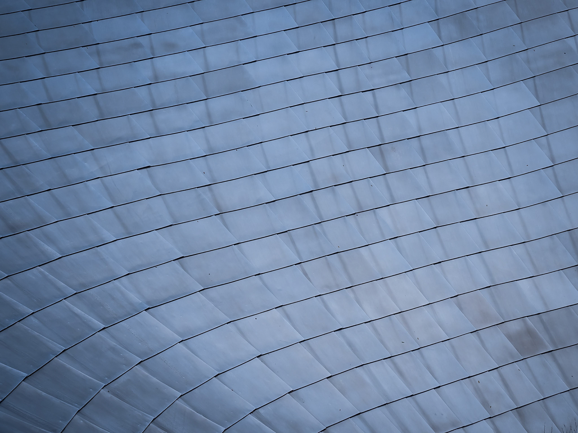 Stainless steel tiles flow along the length of a contemporary bridge in central Chicago