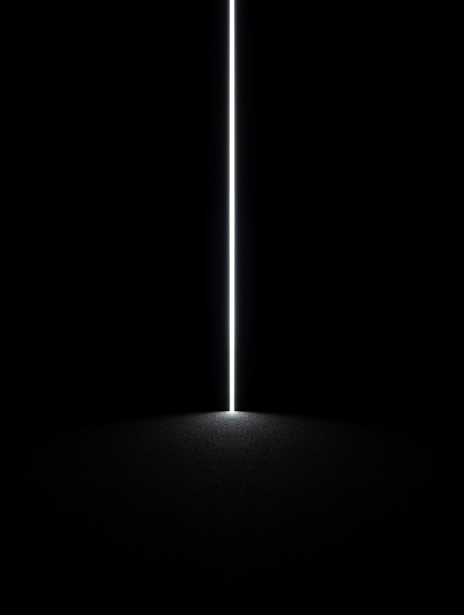 A shaft of pure white light splays onto the foreground of a contemporary light installation