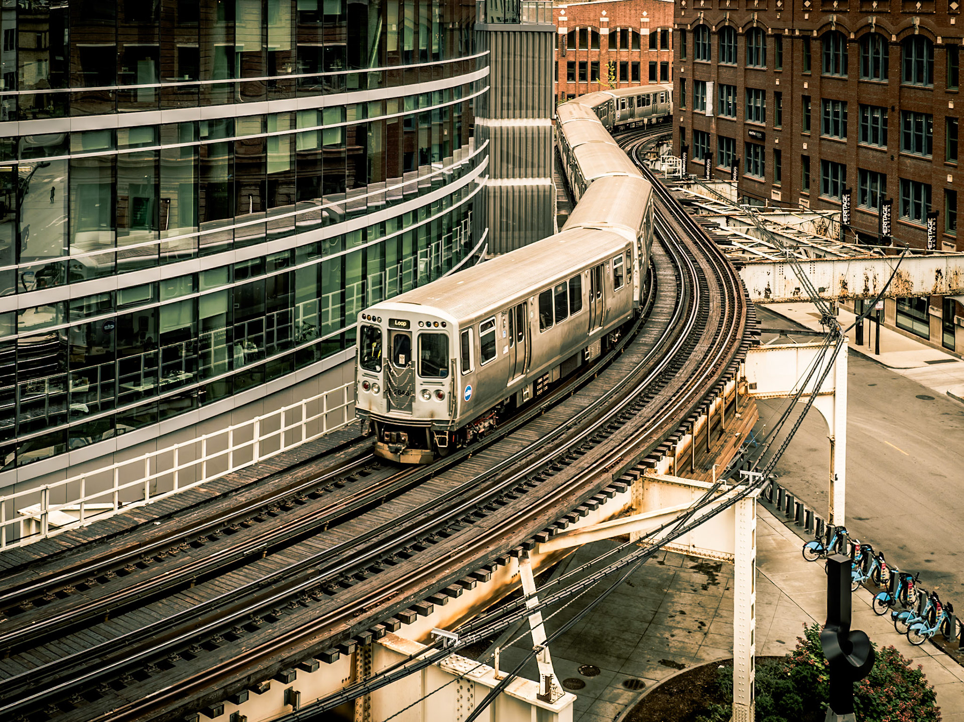 A train on the 'L' negotiates tight bends as the track winds between buildings in the city of Chicago