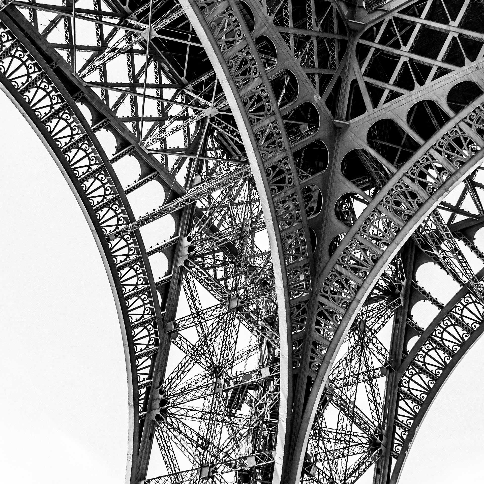 A vintage-style photo of the intricate ironwork forming one of the legs of the Tour Eiffel in Paris