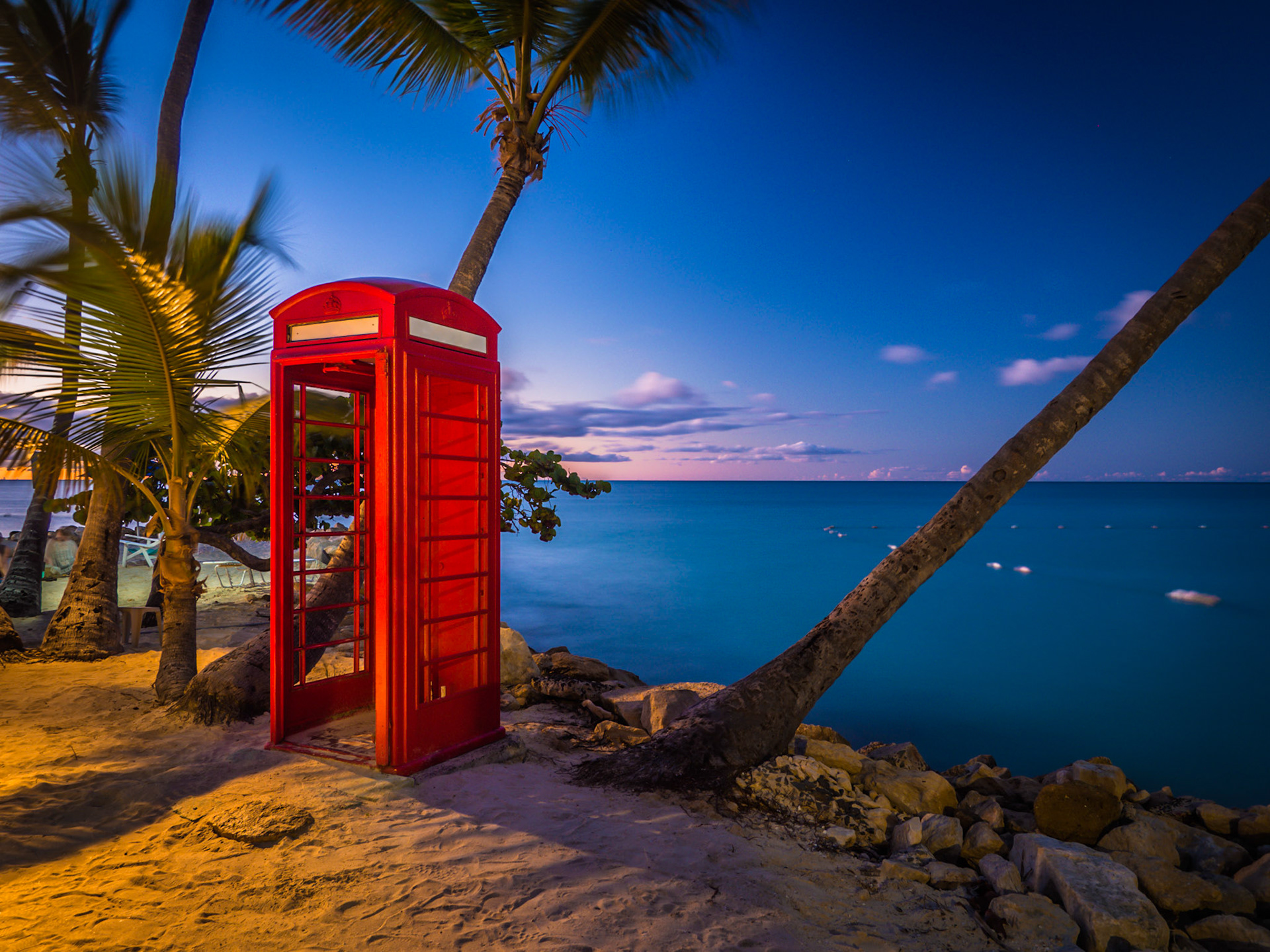 A lone red phone box out of place on a beach on the Caribbean island of Antigua