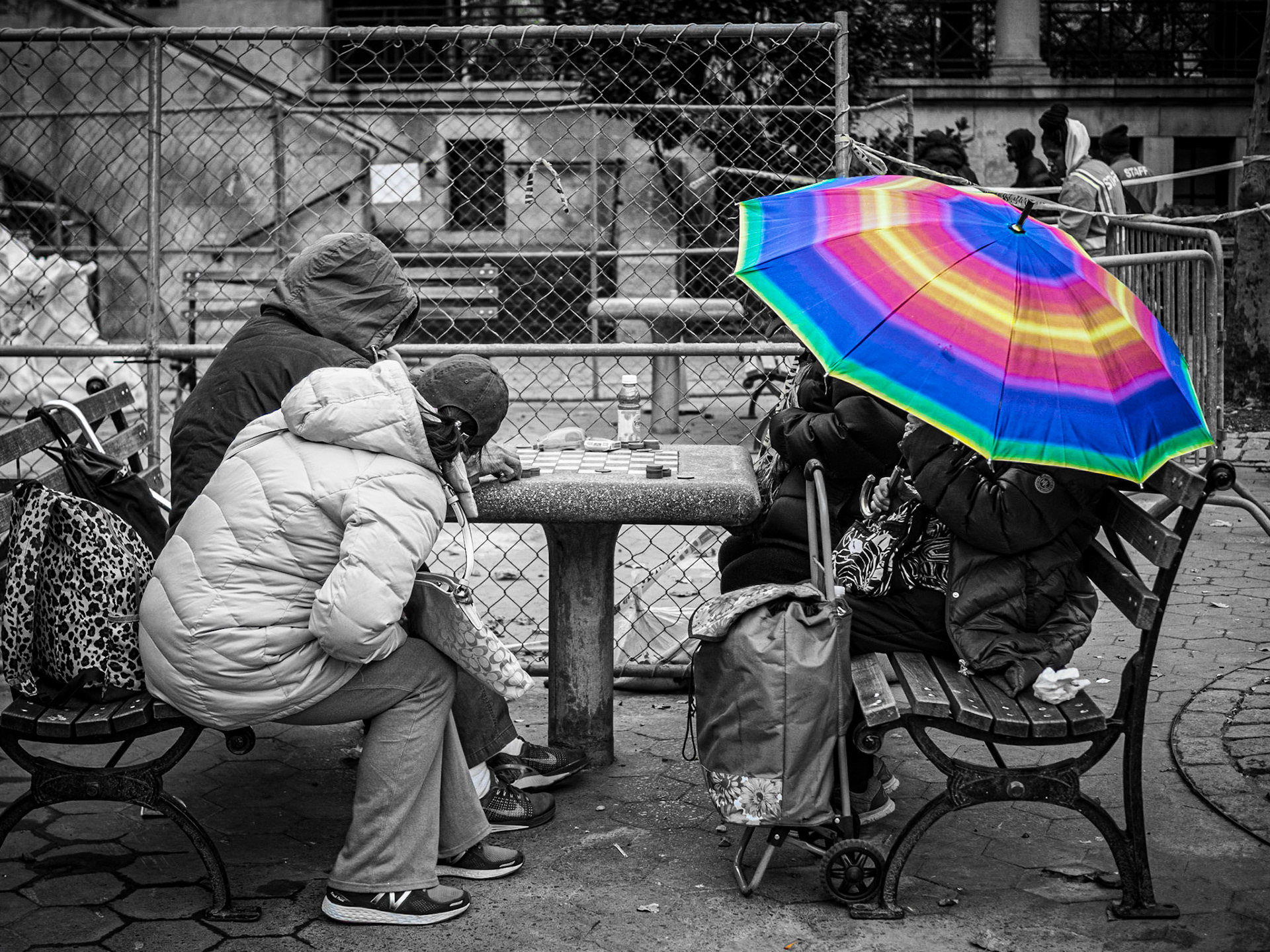 Members of the local Chinese community play draughts in the rain in Columbus Park in Lower Manhattan, New York