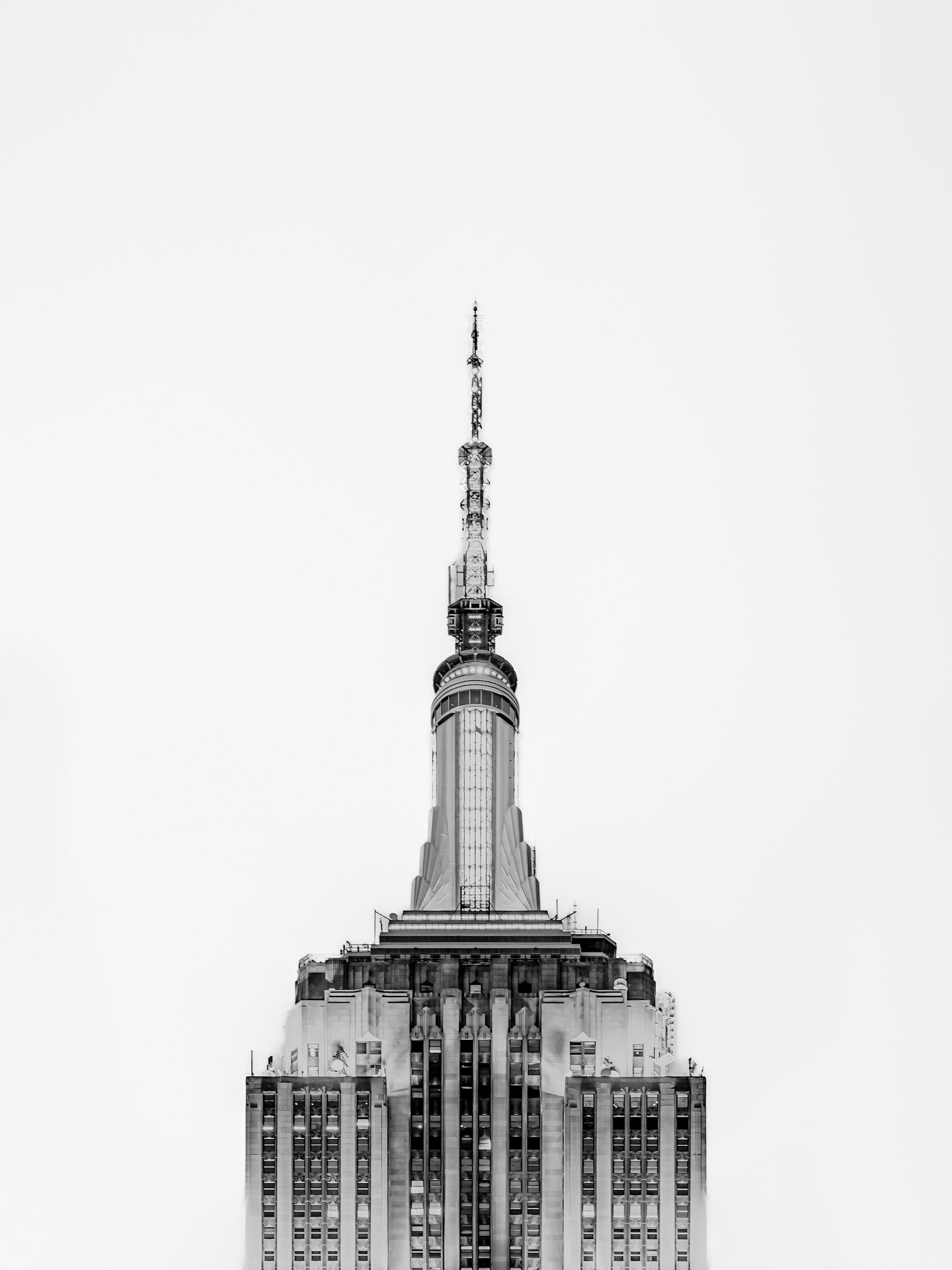 The tip of the Empire State Building soars high into the sky in central Manhattan, New York