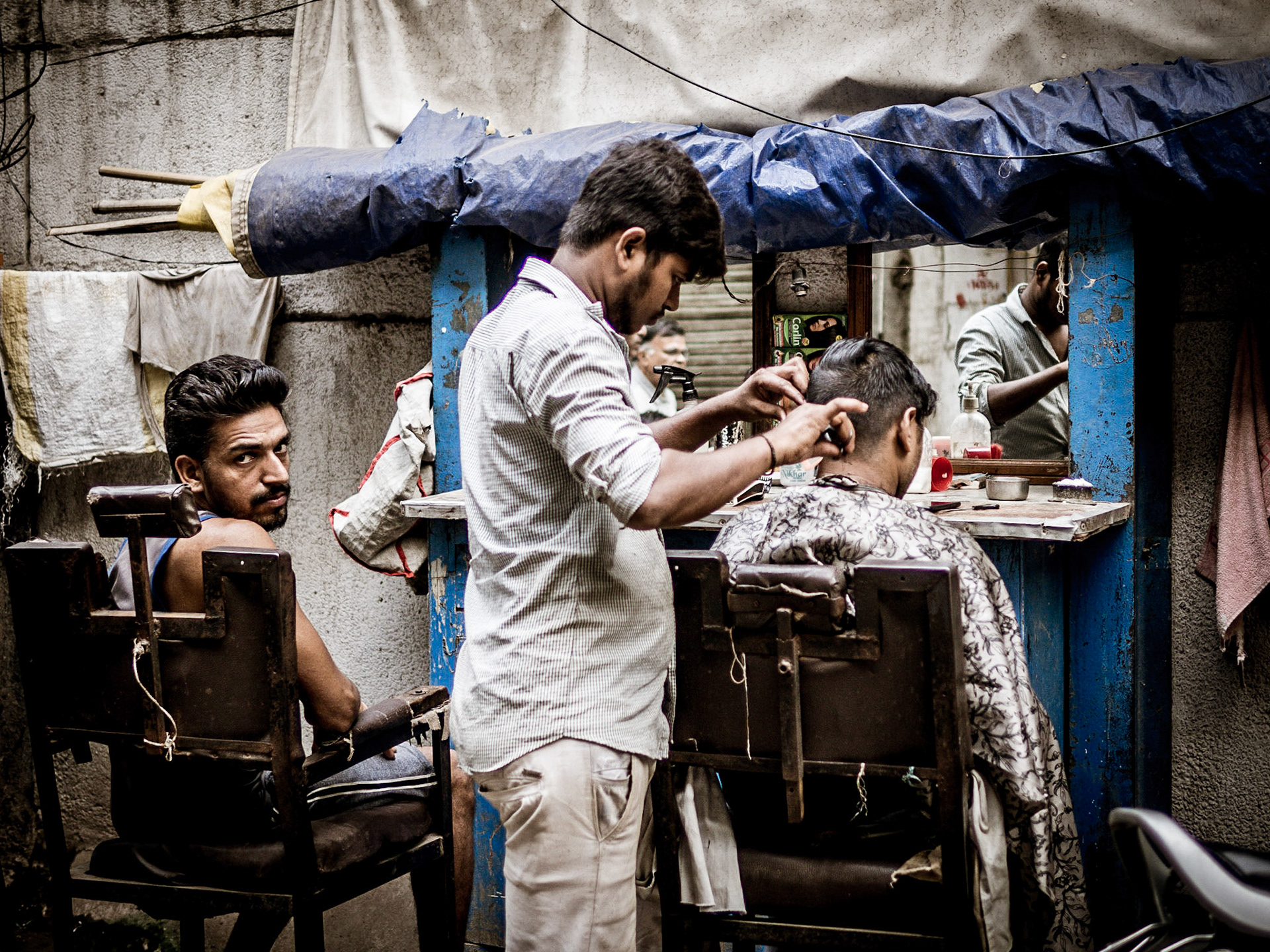 A customer awaits his turn at a barber on the streets of Chandni Chowk in New Delhi