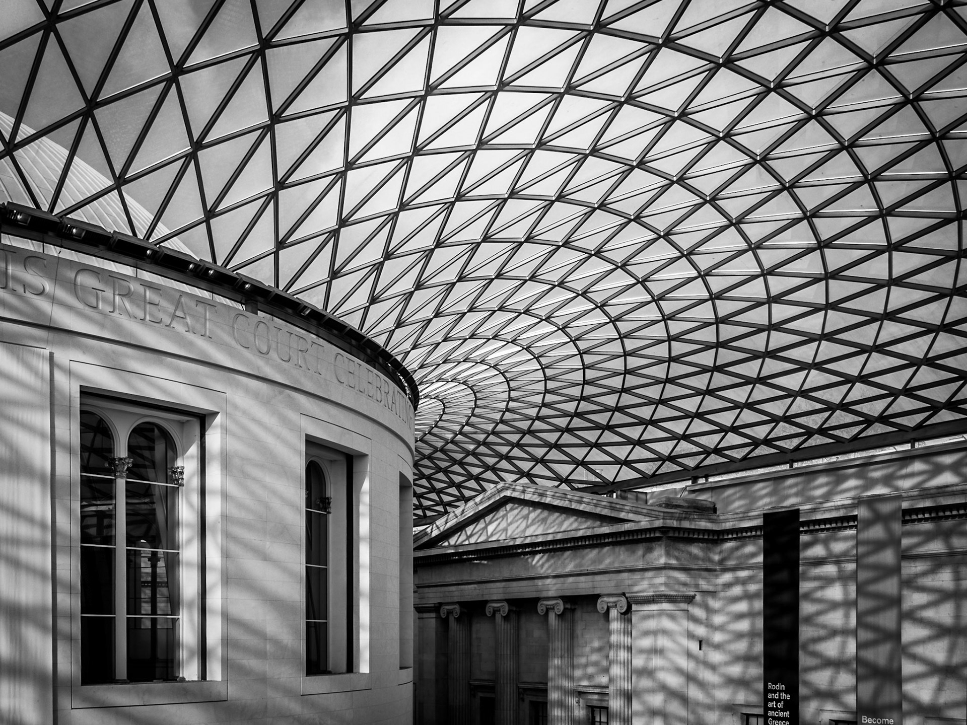 The latticed framework of an atrium casts distinctive shadows over the former courtyard of the British Museum