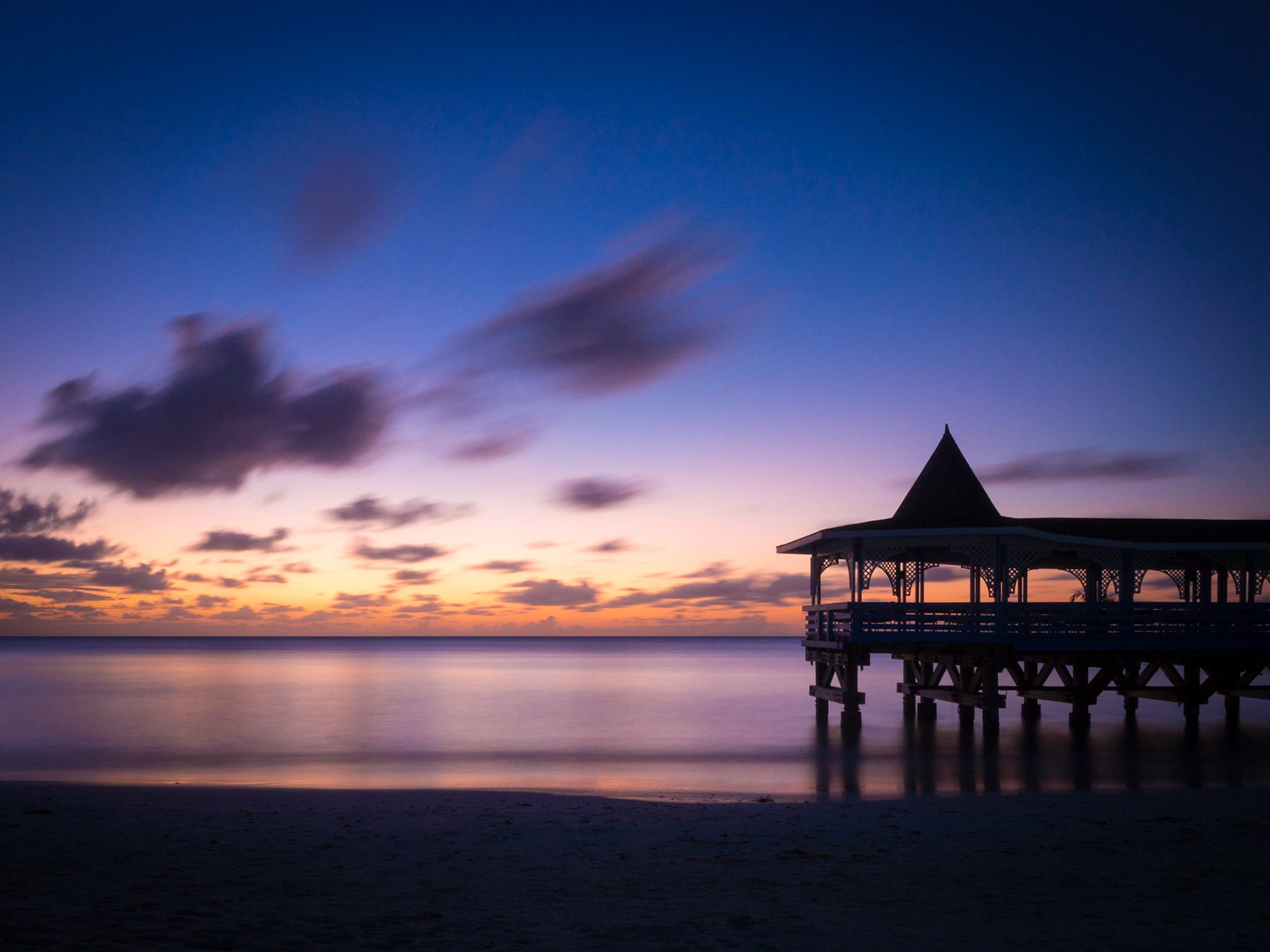 A very late sunset falls behind Warri pier in Dickenson Bay, Antigua
