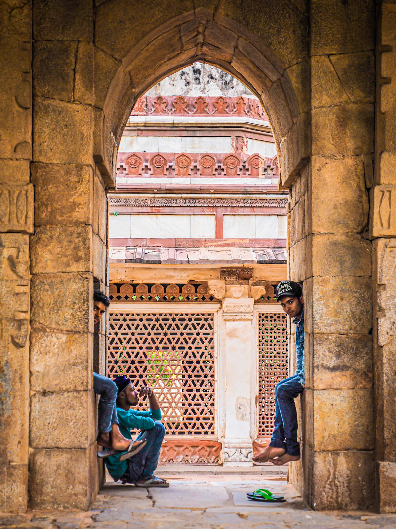A small group of men sitting idle at the historic site of Qutub Minar in New Delhi