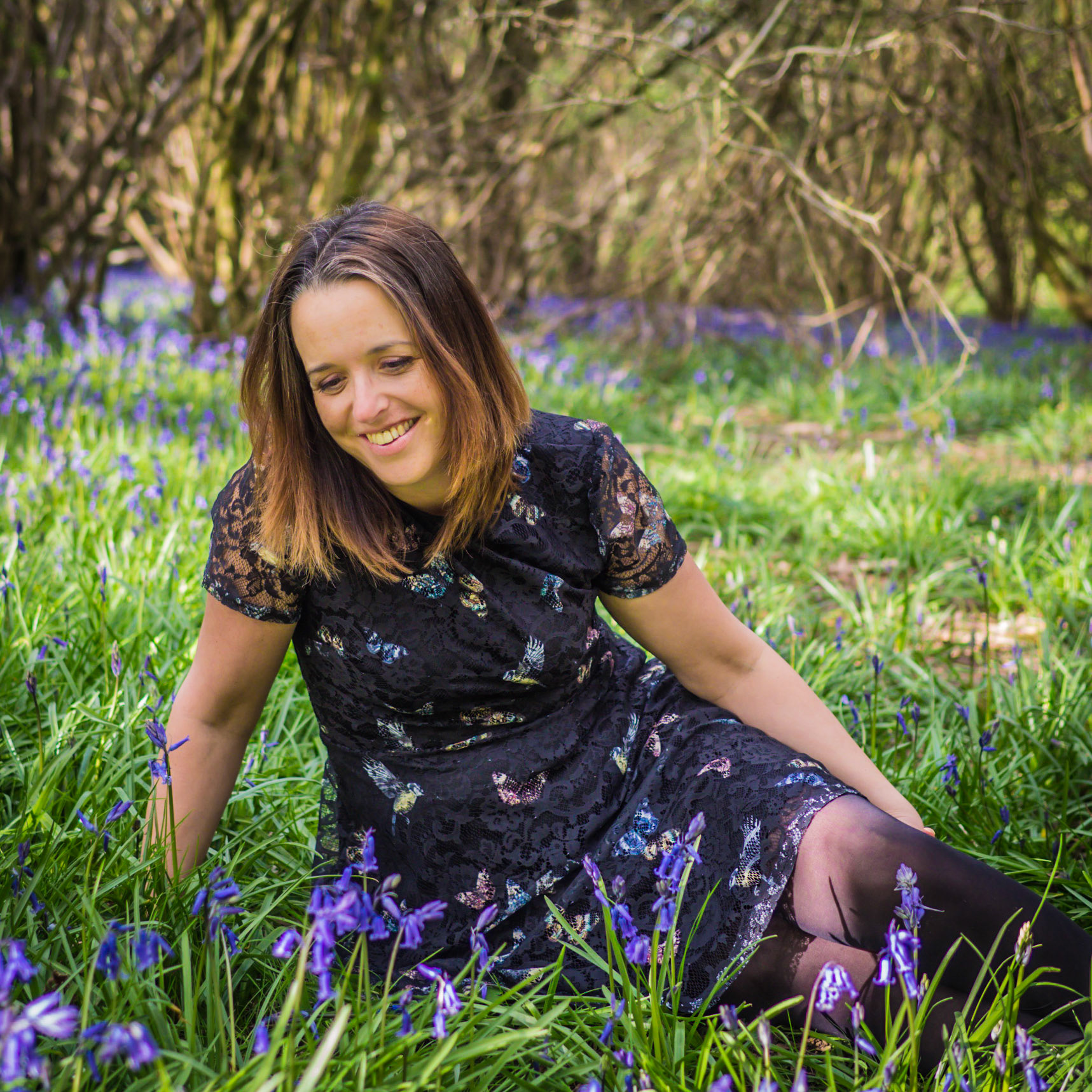 Rebecca sitting on a carpet of bluebells in a Sussex wood