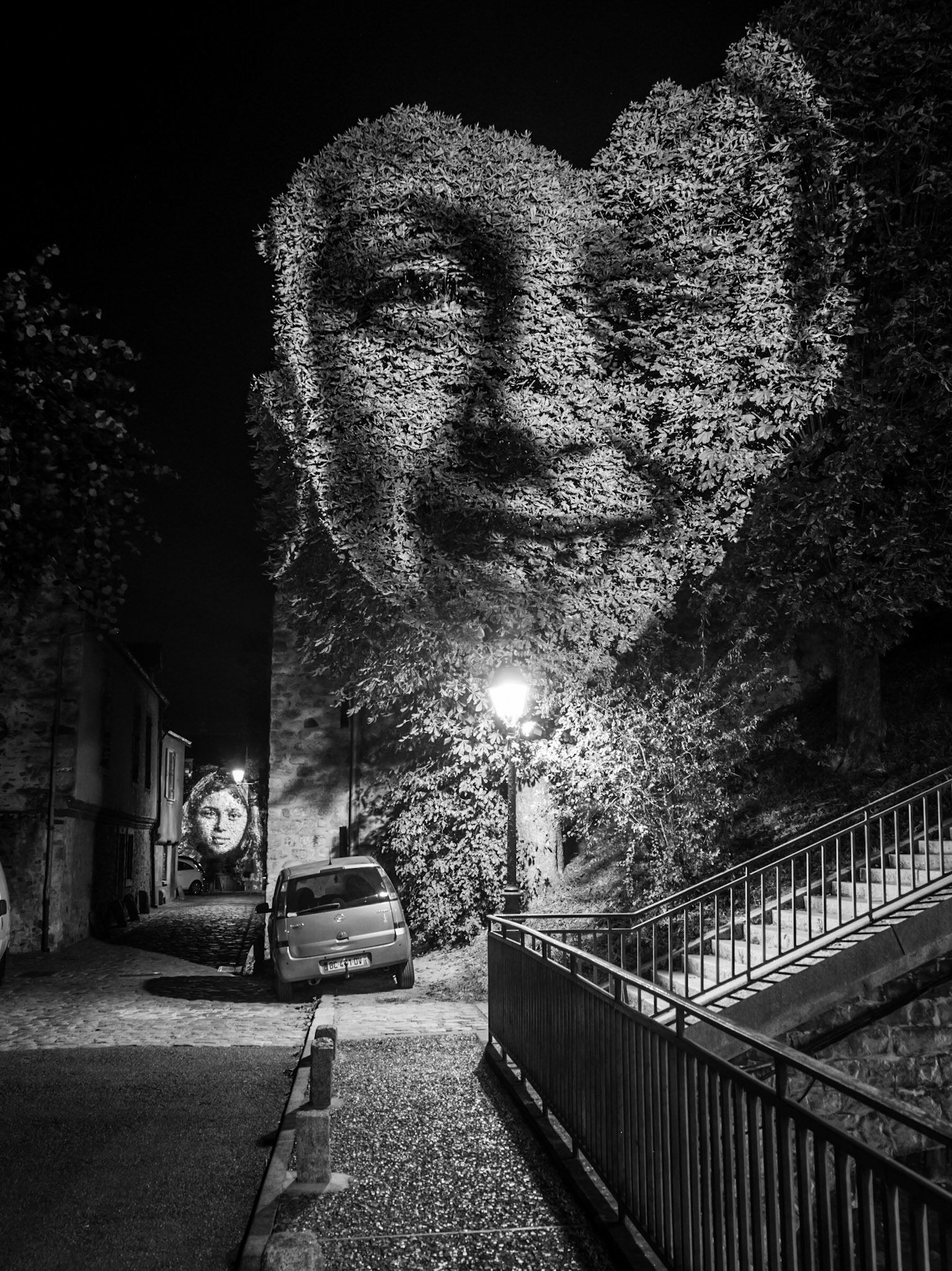 A lone car is parked awkwardly on a side street in Le Mans during the city's annual light festival