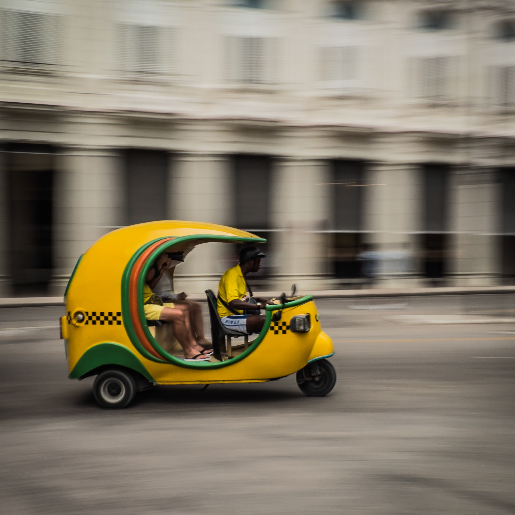 A pair of tourists take a perilous ride in one of Havana's notorious cocotaxis