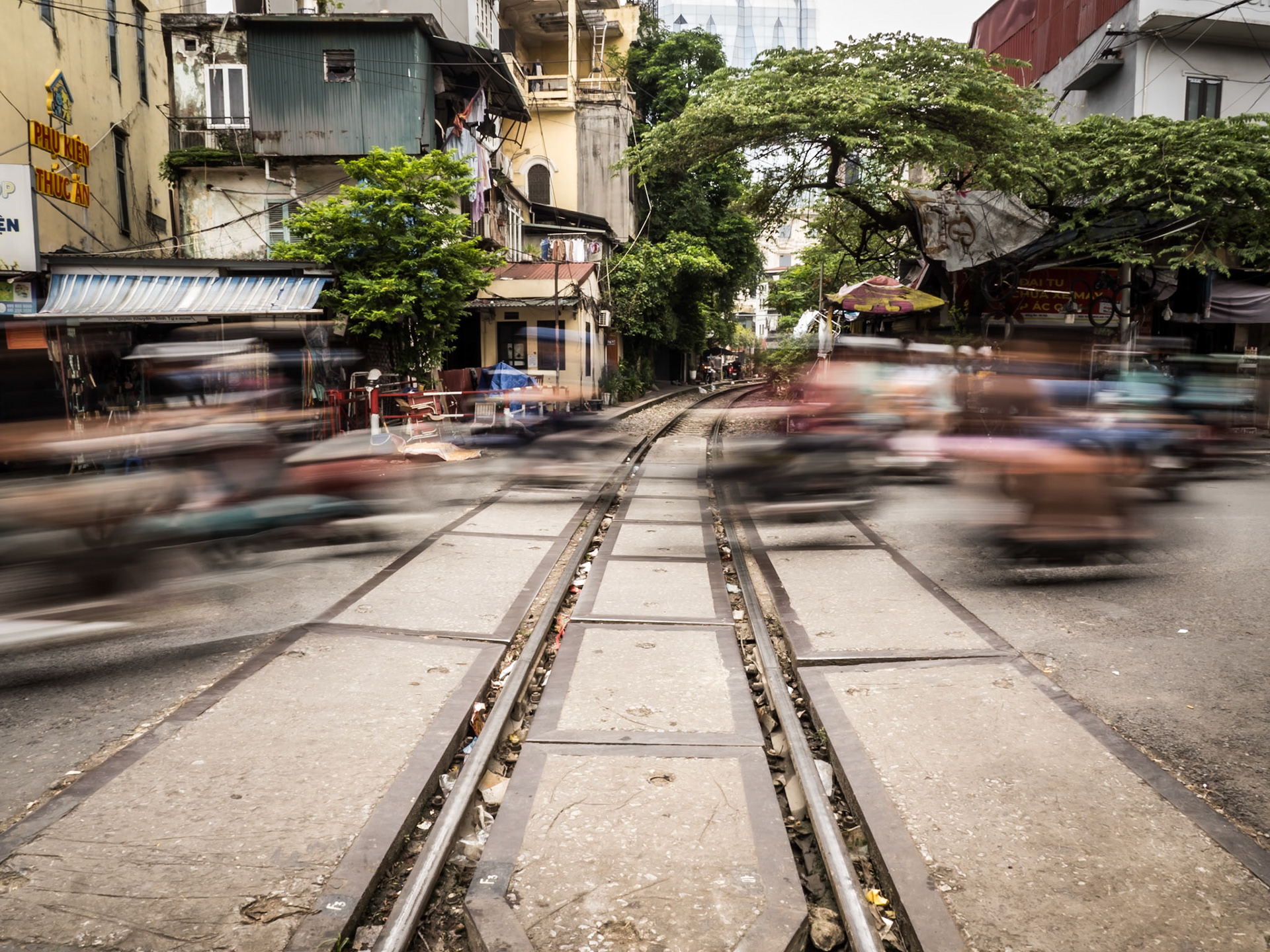 During the morning rush-hour, mopeds speed across a railway track that carves its path through central Hanoi in Vietnam