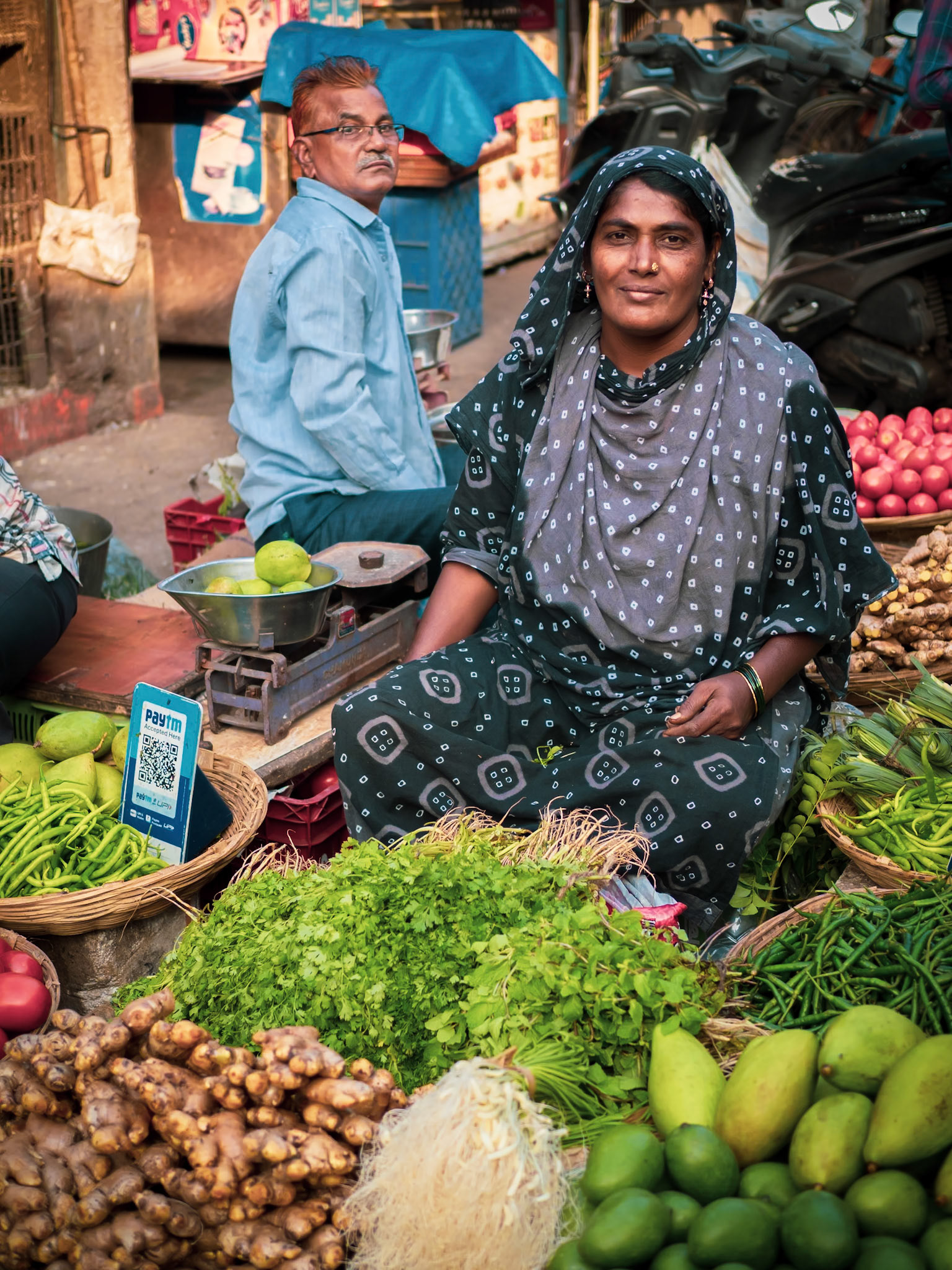 A husband-and-wife team watch over their stall of vegetables with pride in a small street market in Mumbai