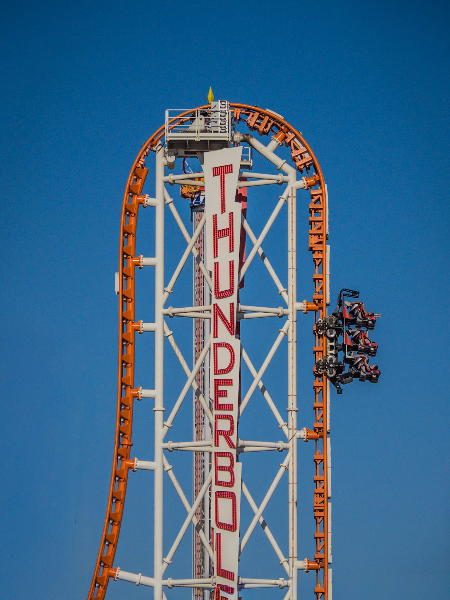 Thrill-seekers cling on as they climb vertically to the peak of the Thunderbolt roller-coaster in New York's Coney Island