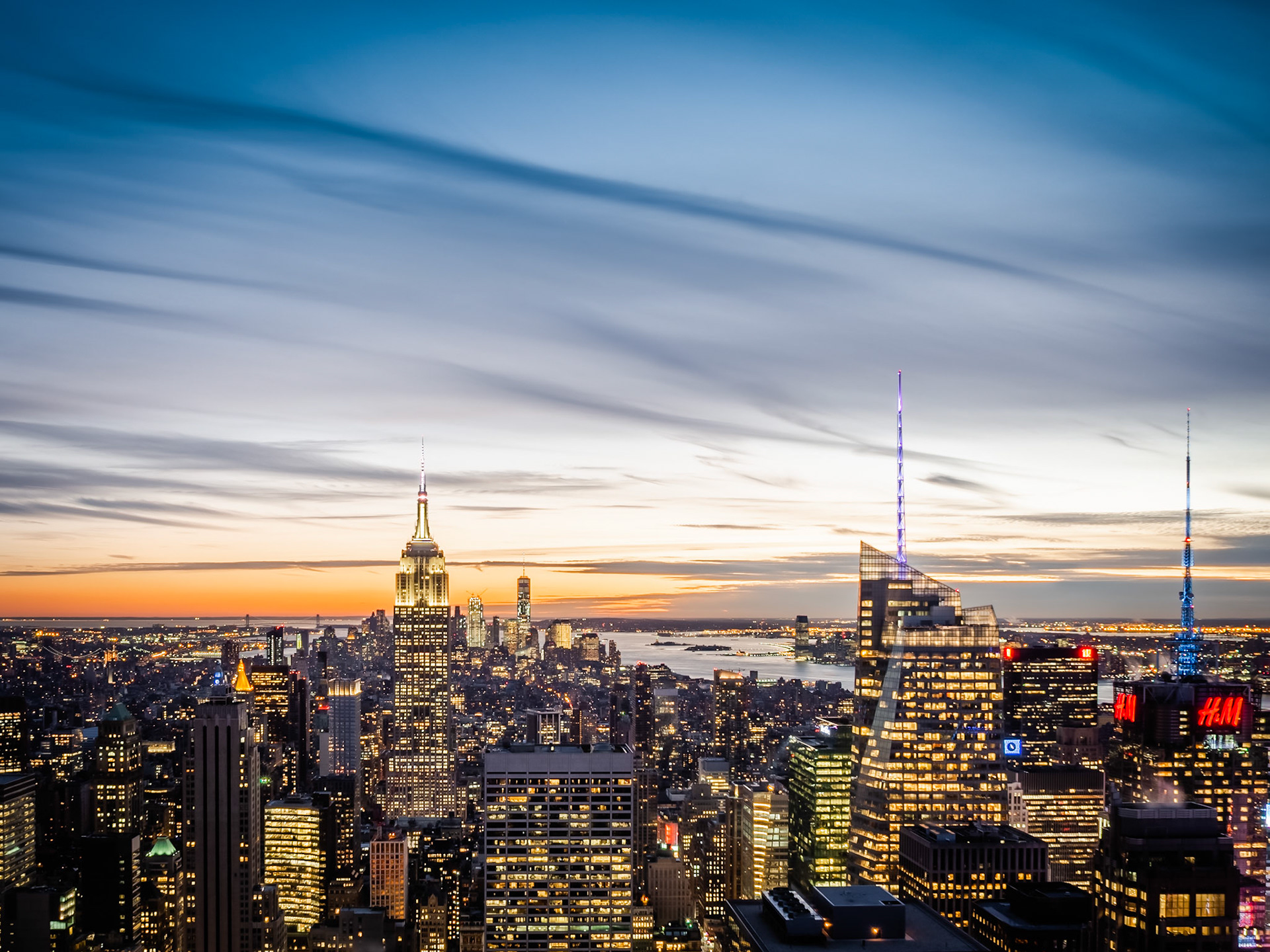 The Manhattan skyline with the Empire State Building standing resplendent in Mid-Town New York as the sun sets beyond the Hudson River