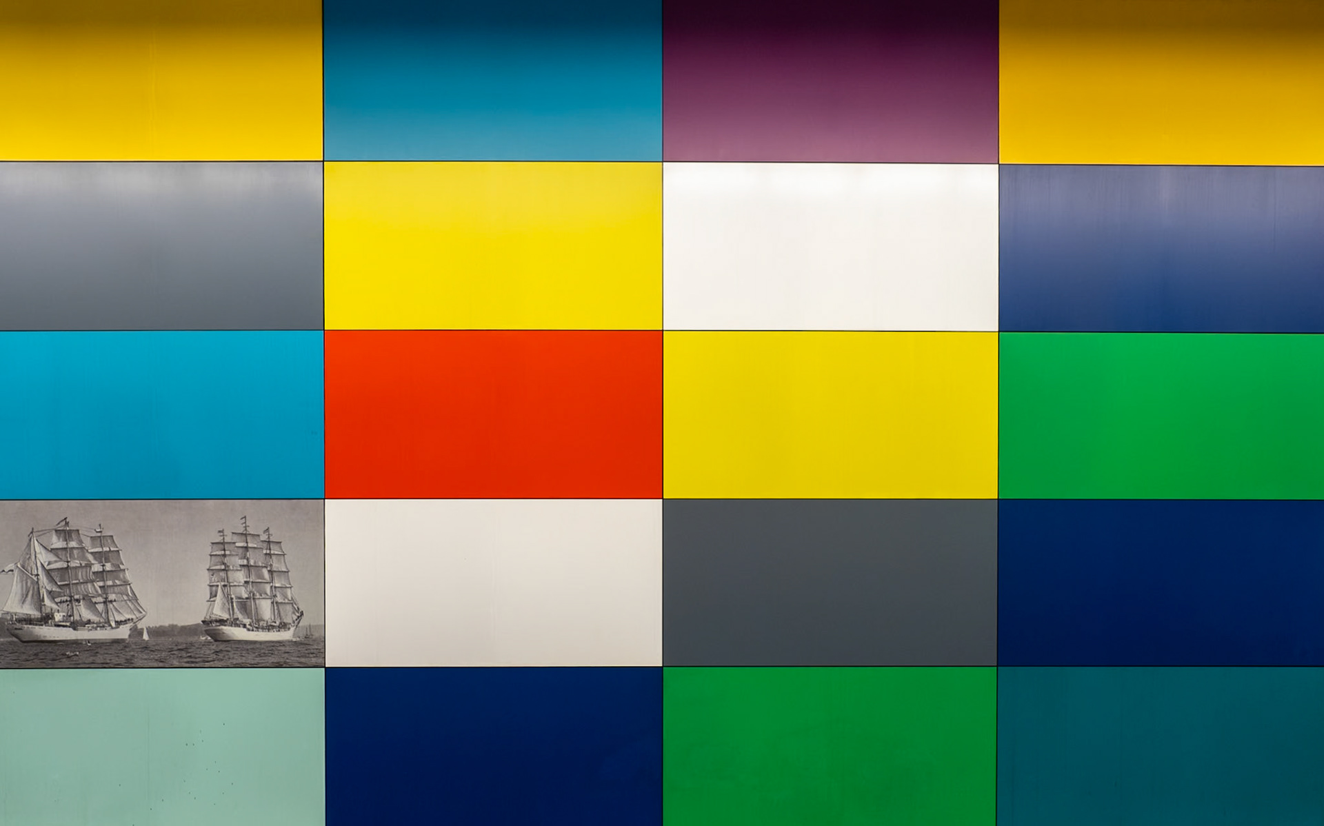 Coloured blocks line the walls of a bright U-Bahn station in Munich
