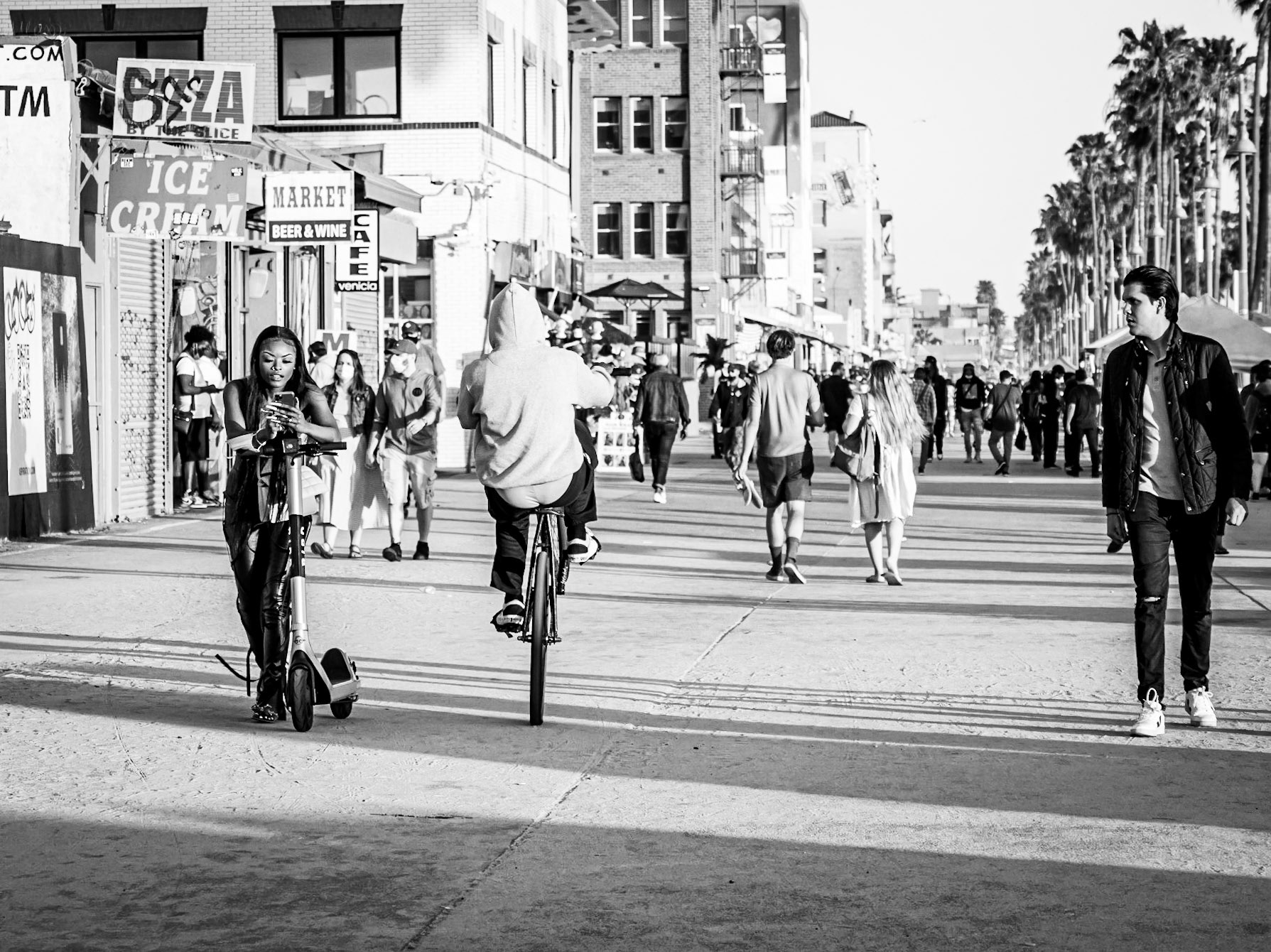 A girl is oblivious to a man's stunt as he passes by, with another admirer looking on