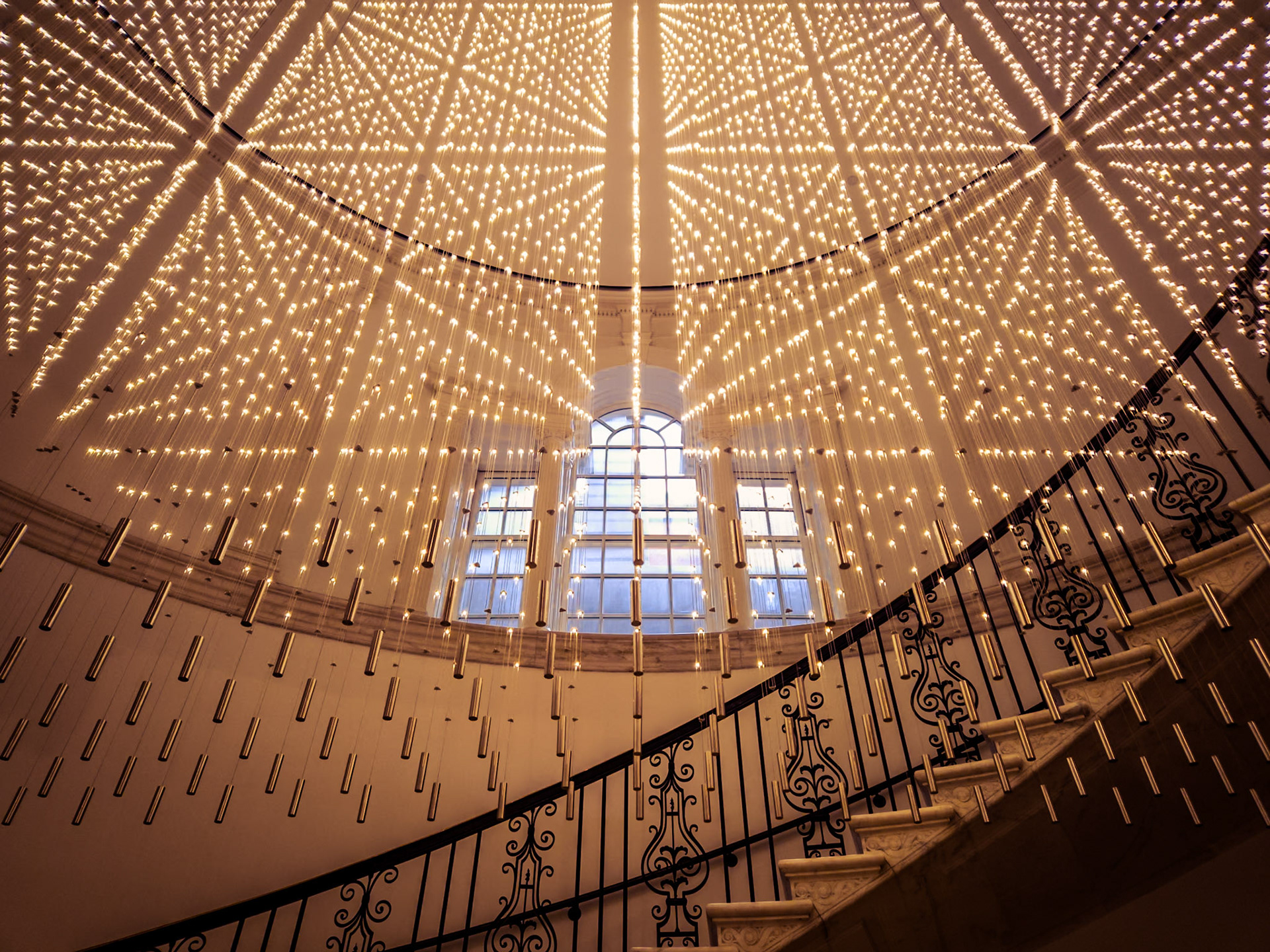 Thousands of small lights form a contemporary art installation along the curved staircase of the Museum of the City of New York