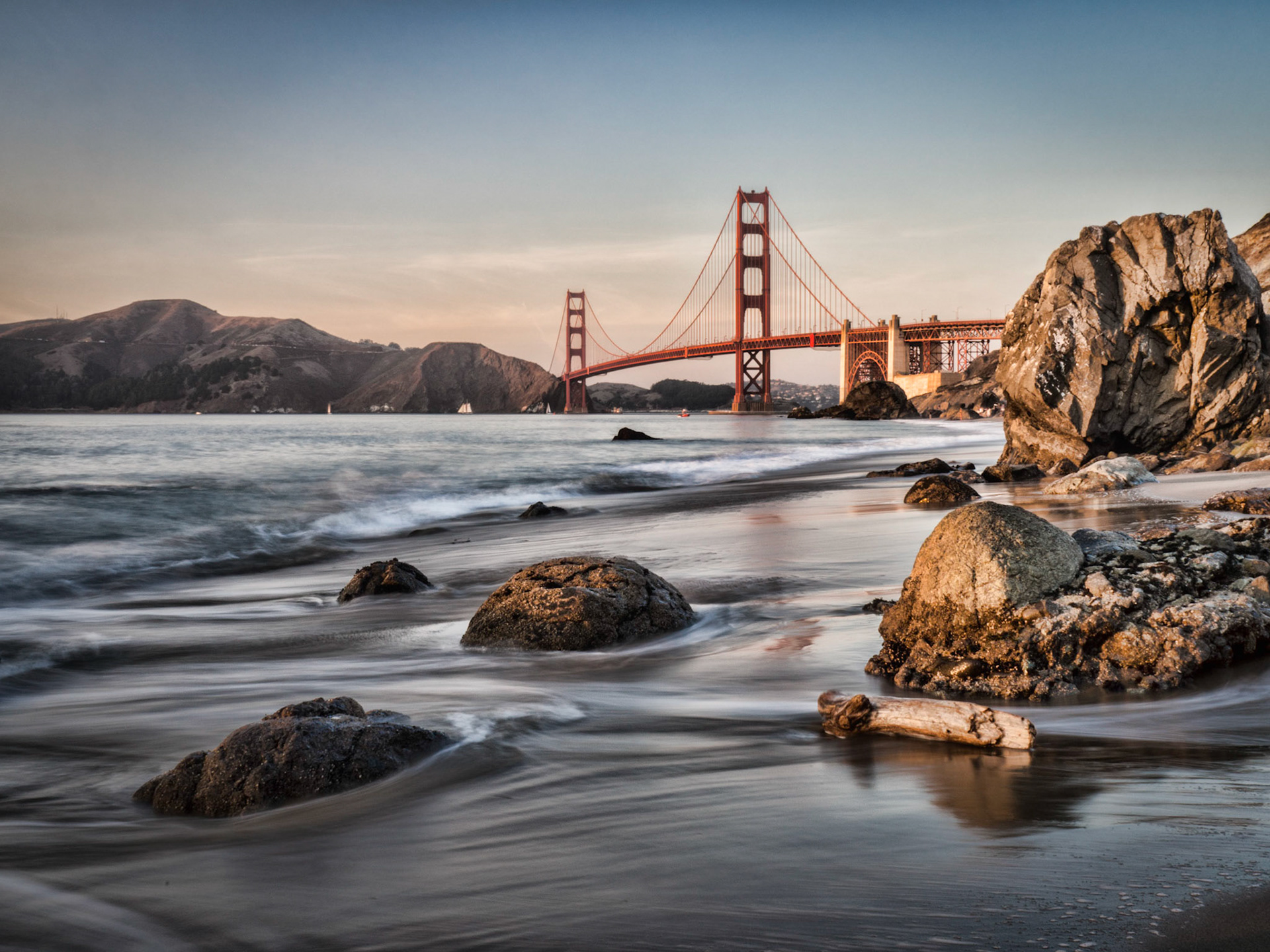Driftwood washes ashore on Marshall Beach, San Francisco, overlooking the Golden Gate Bridge