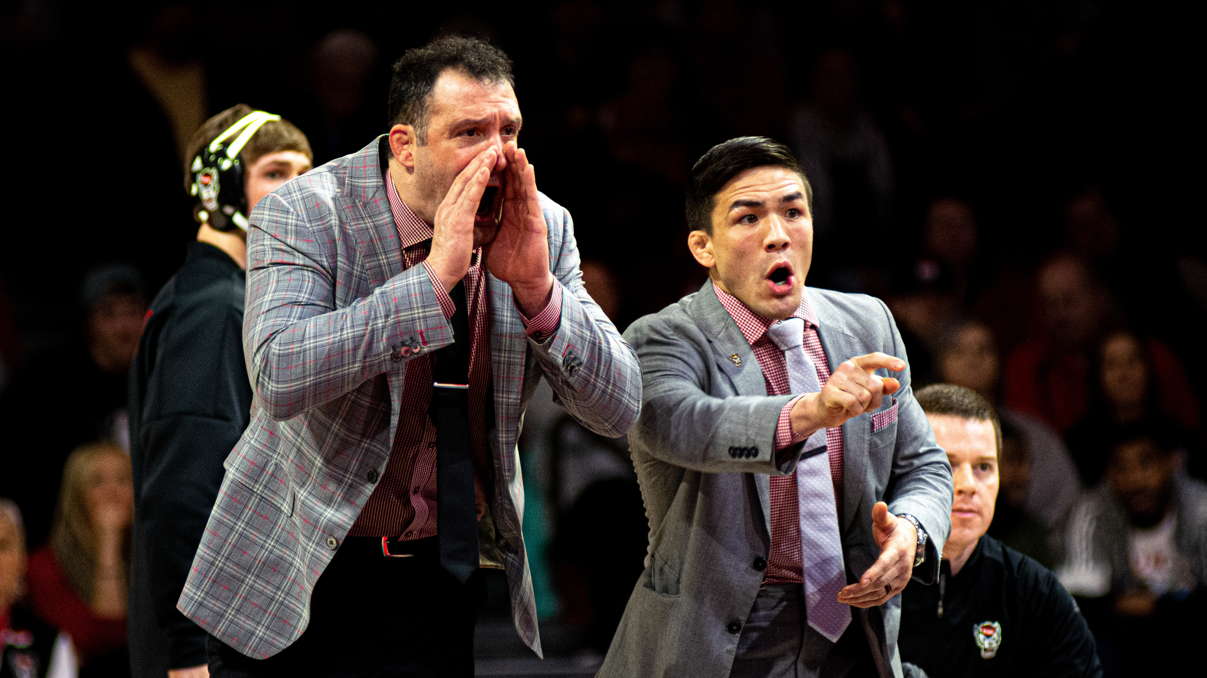 Head coach Pat Popolizio (left) and associate head coach Adam Hall encourage the Wolfpack against UNC-Chapel Hill on Feb. 7, 2020.