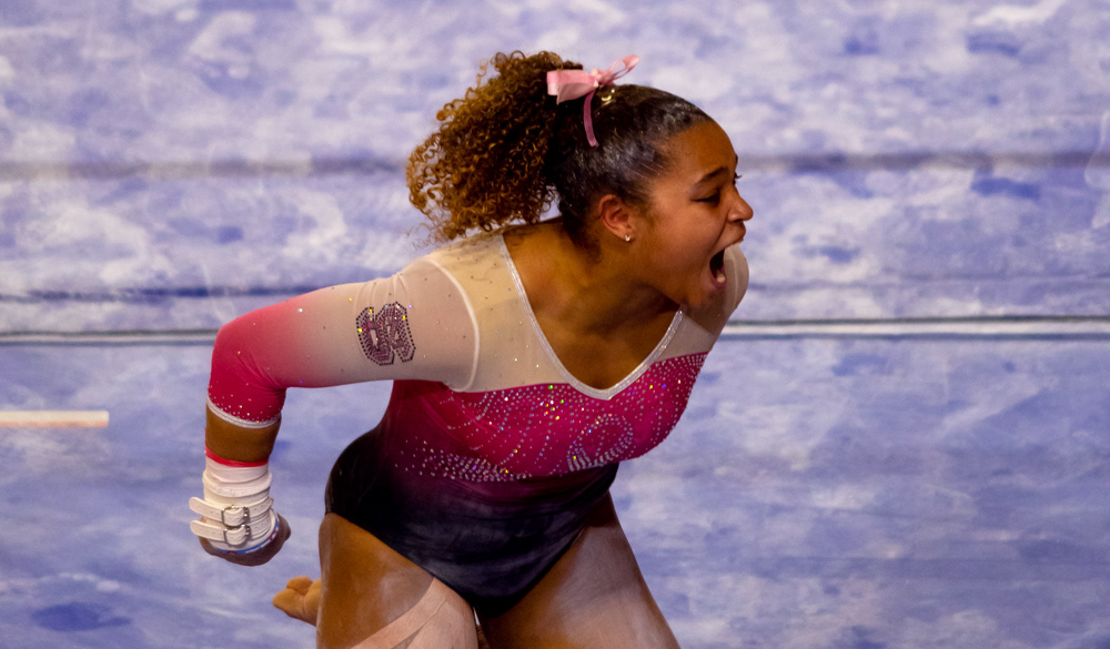 Carina Jordan celebrates a successful uneven bars routine on Feb. 6, 2021.