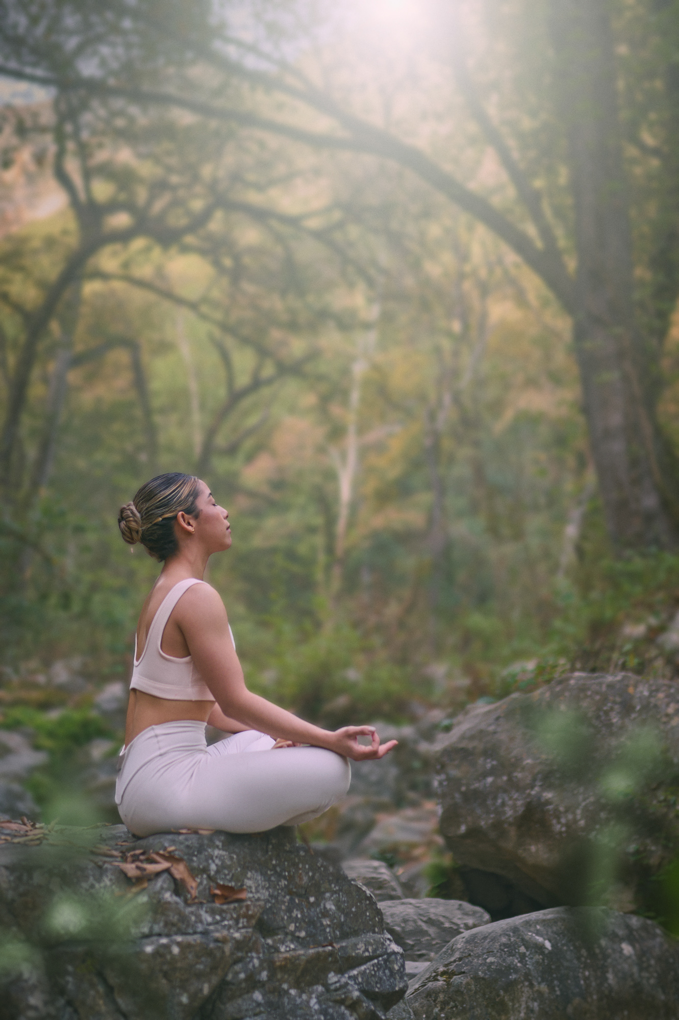 Mujer sentada en meditación sobre terreno rocoso
