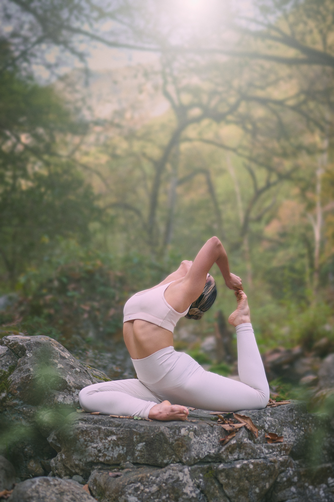 Mujer practicando postura de yoga sentada entre árboles
