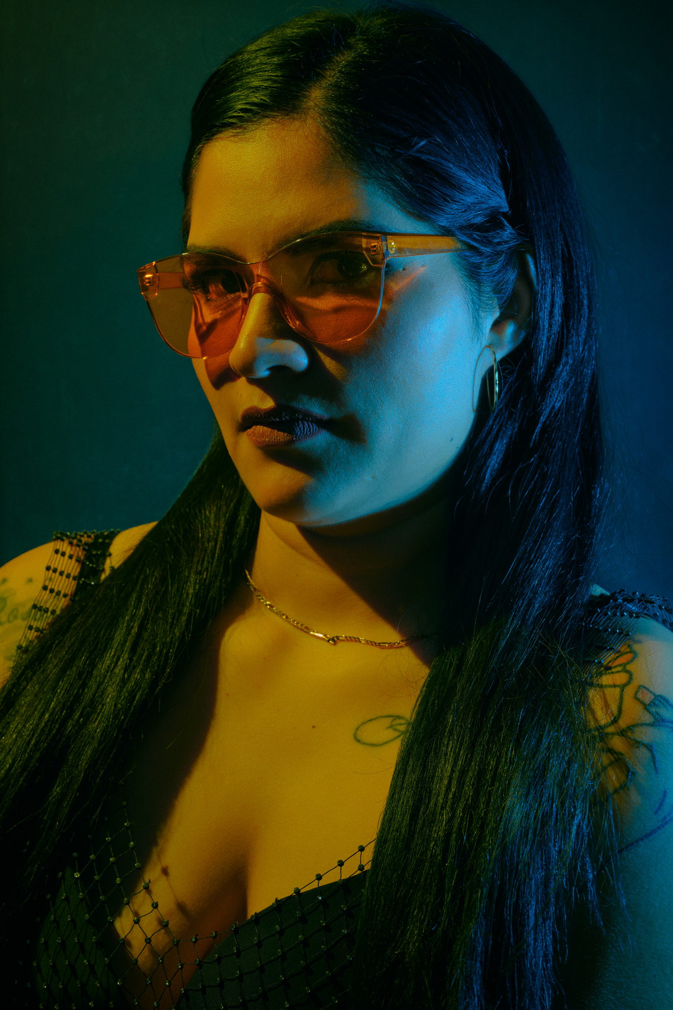 Retrato de persona con gafas y luz azul y naranja