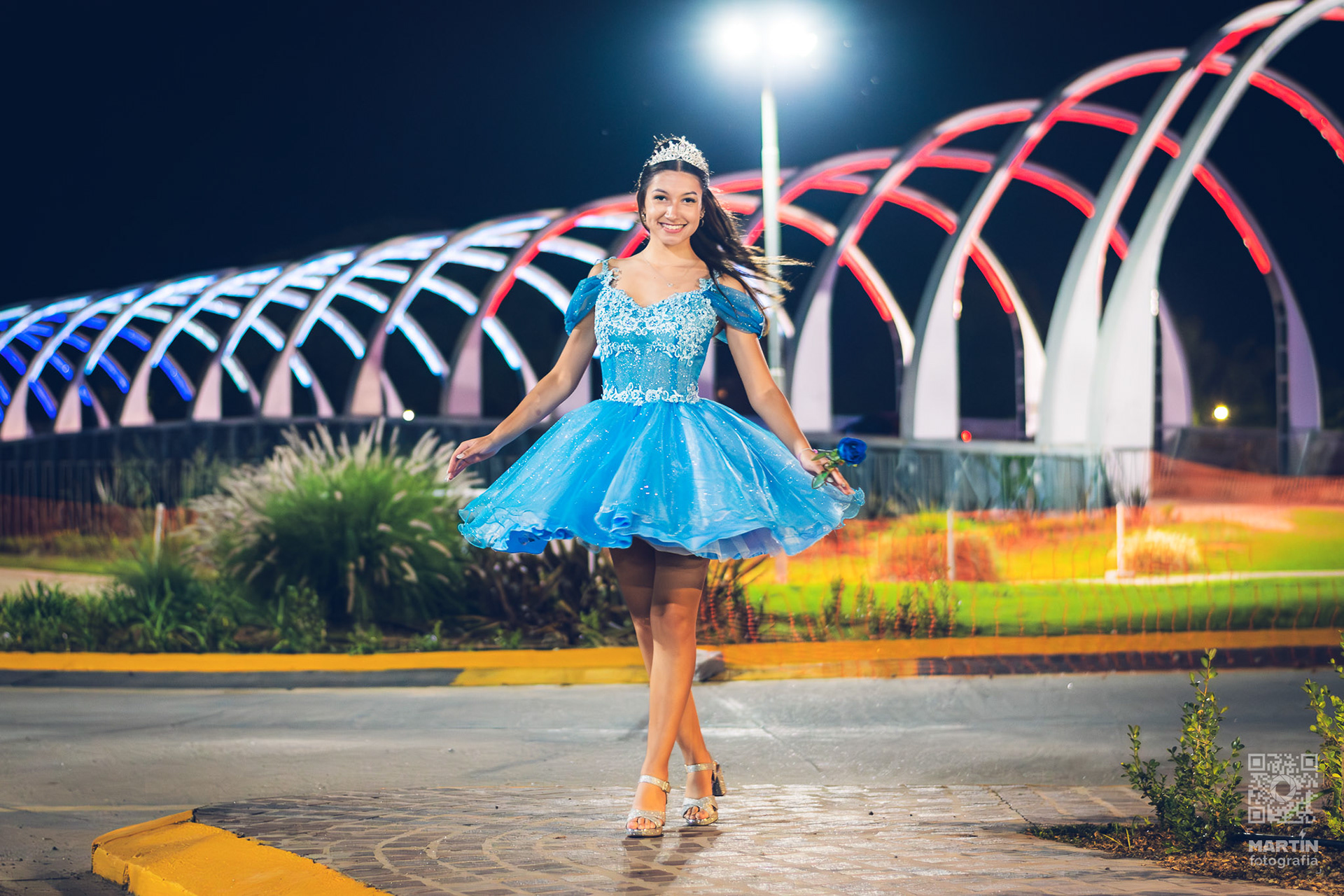 La estructura iluminada aporta líneas y colores que realzan la elegancia del vestido.