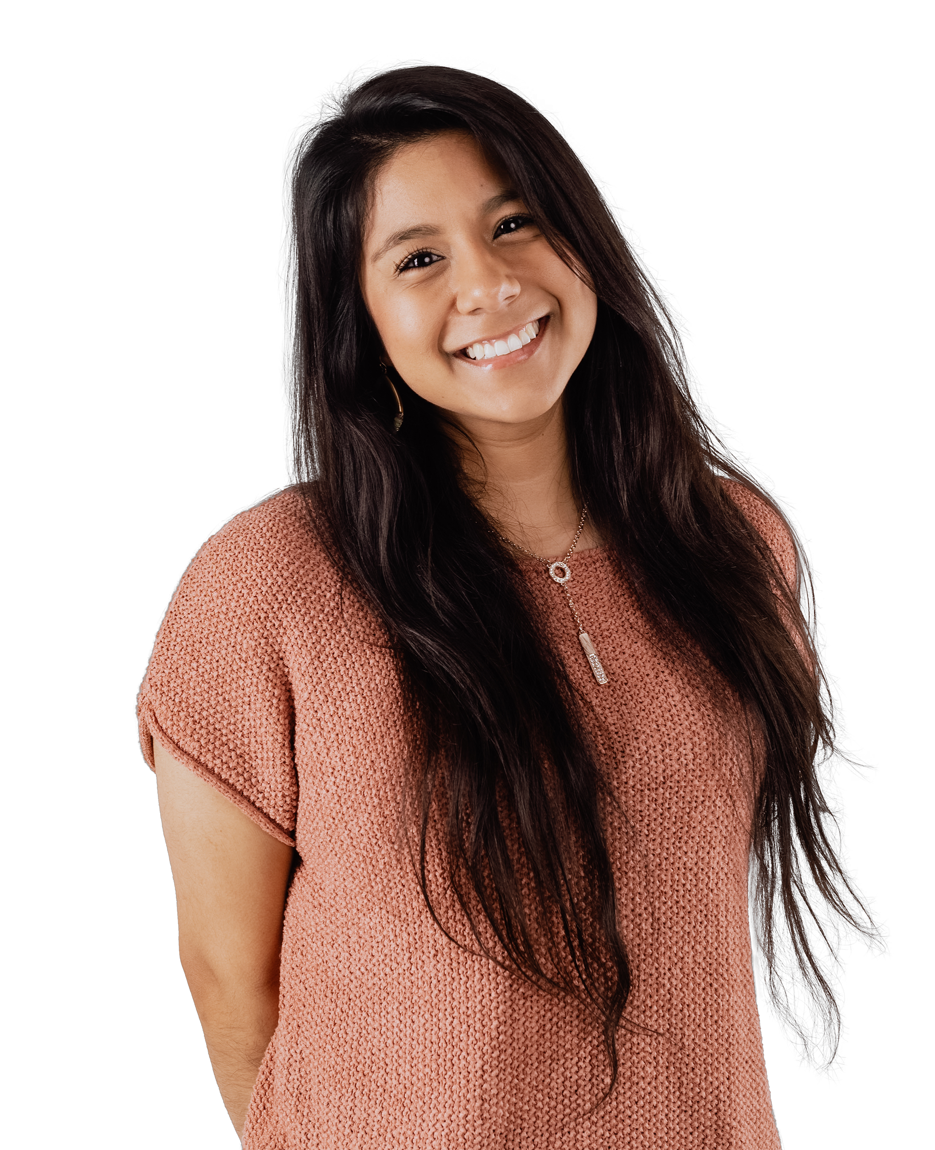 Portrait of Mandy Smiling at the camera, hands behind her back. She is hispanic with long, dark hair. She is wearing a dressy, short sleeve knit top.
