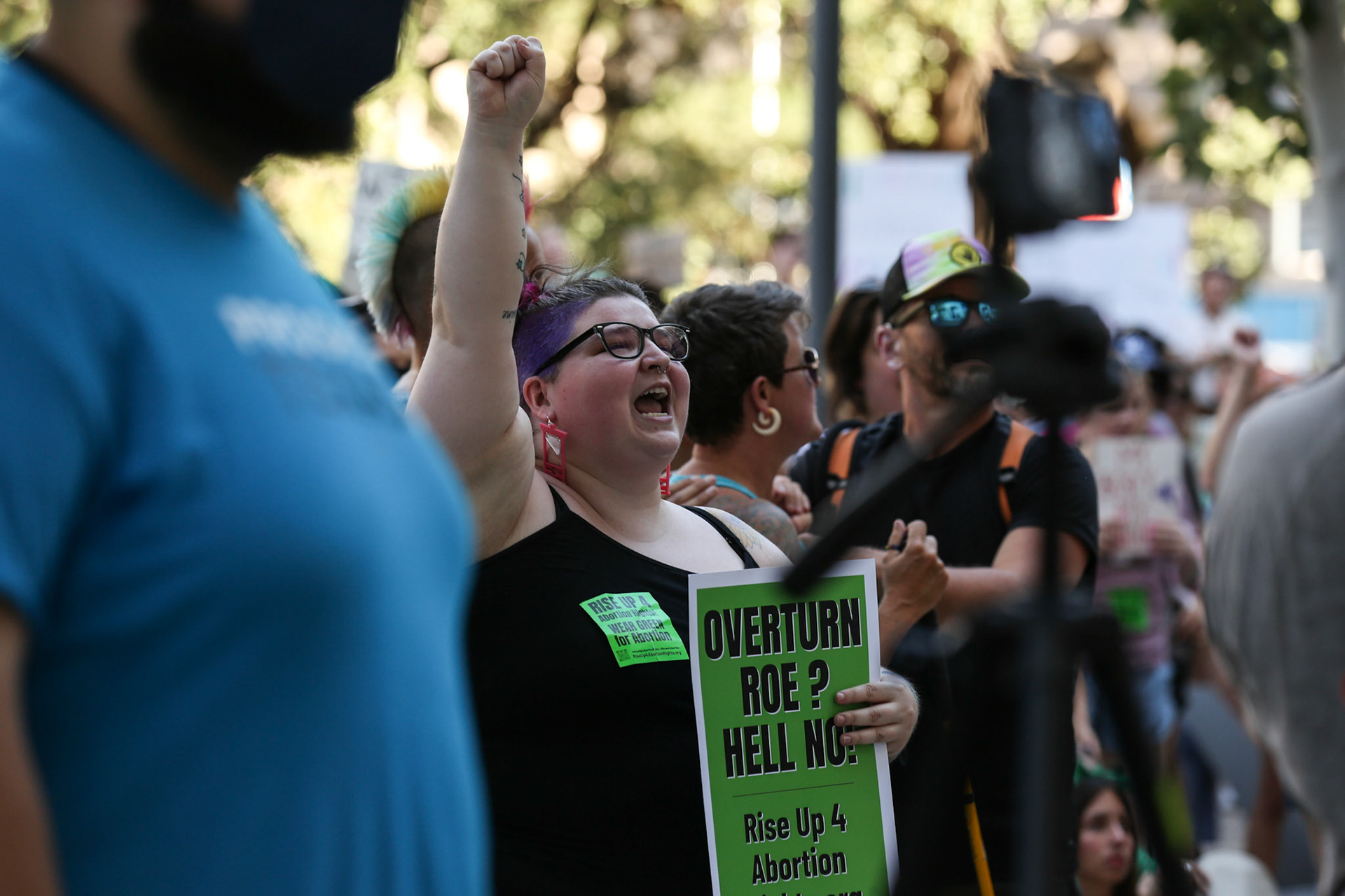 A woman holds her fist in the air at the Federal Courthouse Plaza on June 24.