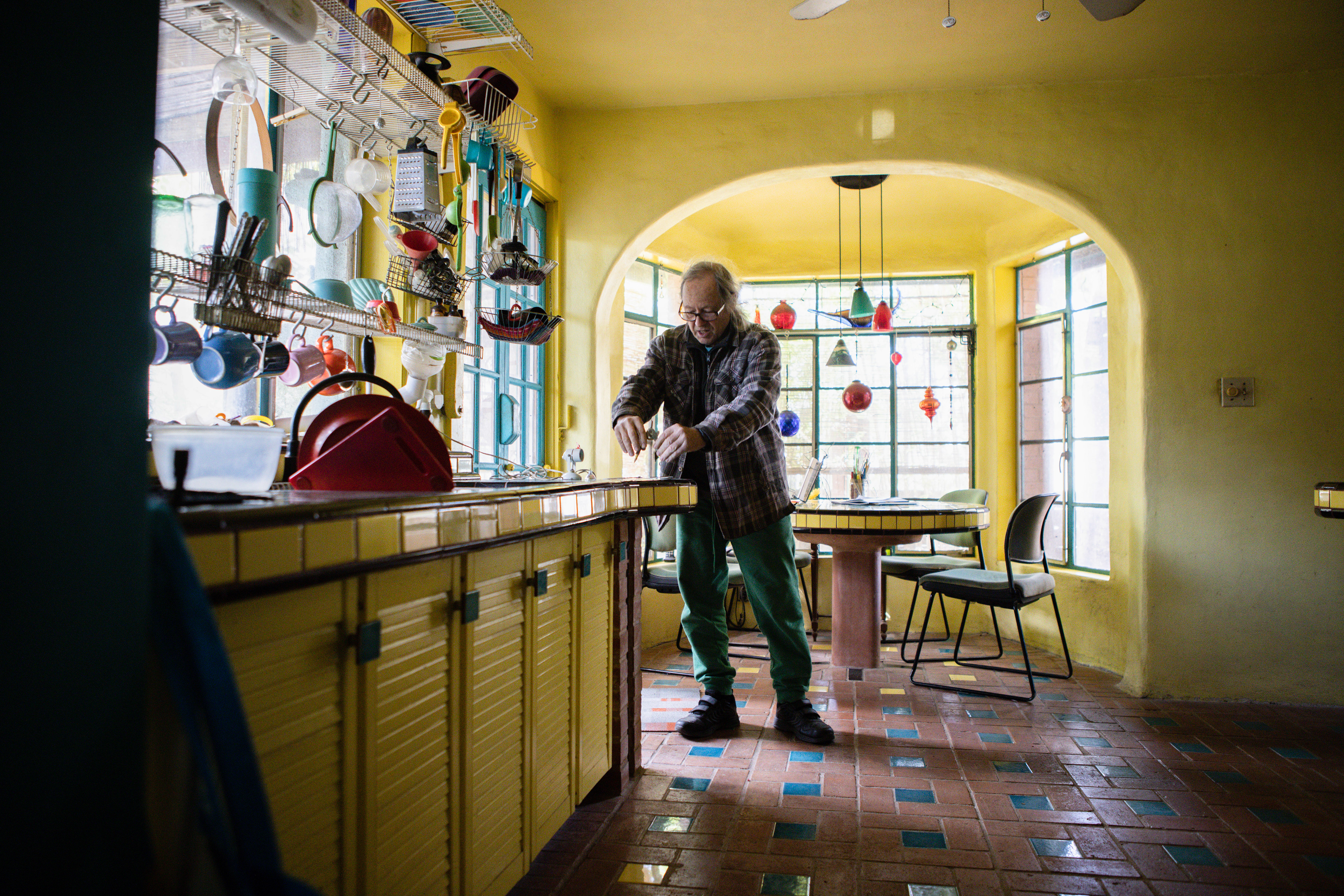 Talbot tests a compass in his kitchen. The kitchen, accentuated with bright colors and decorations, was designed early in his time at Casa Neverlandia.