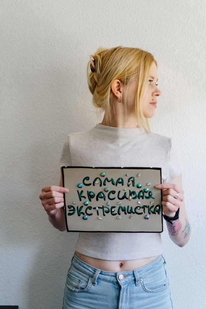 Blonde Frau mit Schild von Dokumentarfotografin Oxana Guryanova