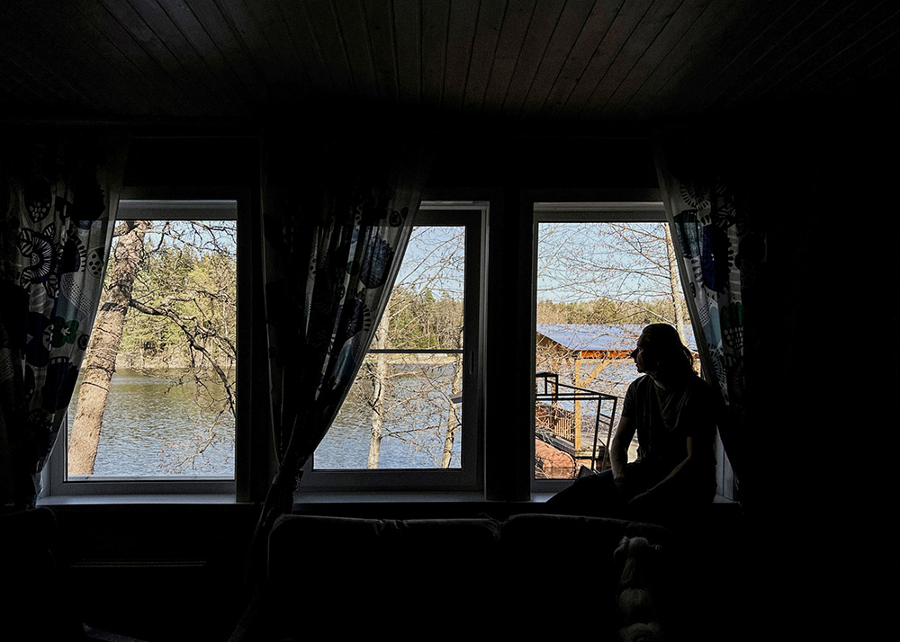 Silhouette einer Person an einem Fenster mit Blick auf einen Fluss Fotografie von Oxana Guryanova