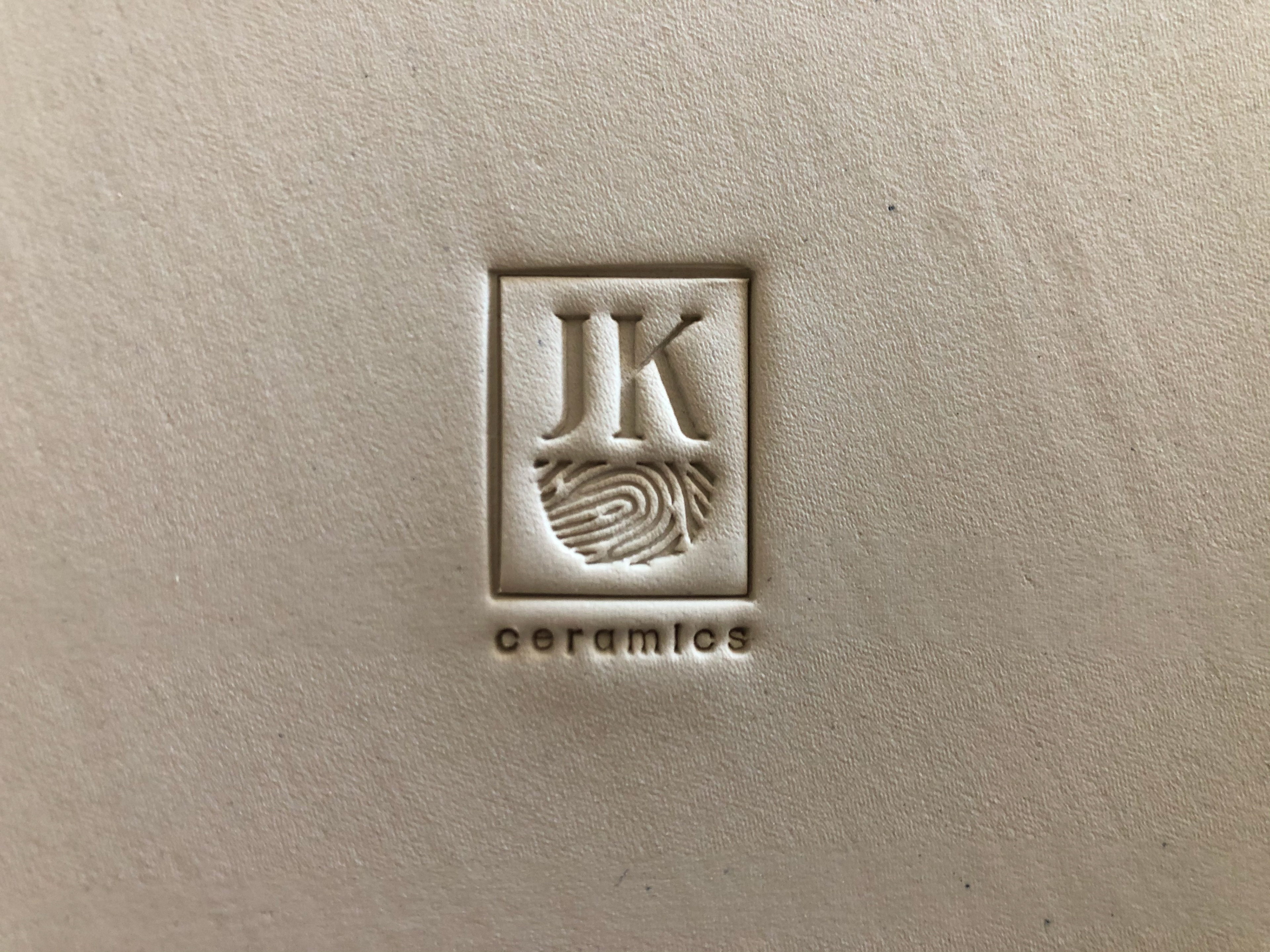 Jenny Kramer Ceramics monogram stamp design seen pressed into the bottom of pot showcasing a thumbprint in shape of a pot
