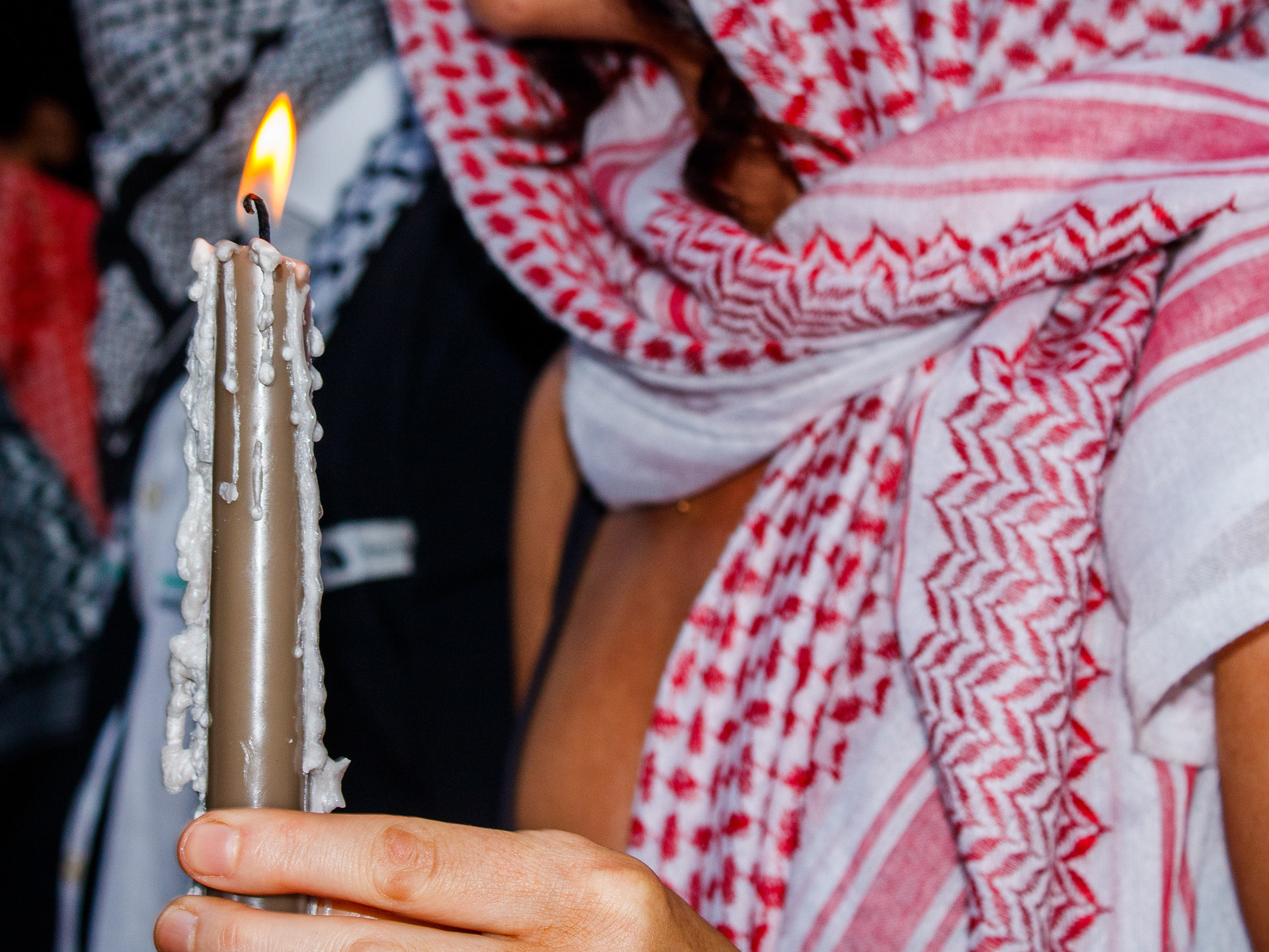 August 13th, 2025 - Protesters hold a candle at a vigil