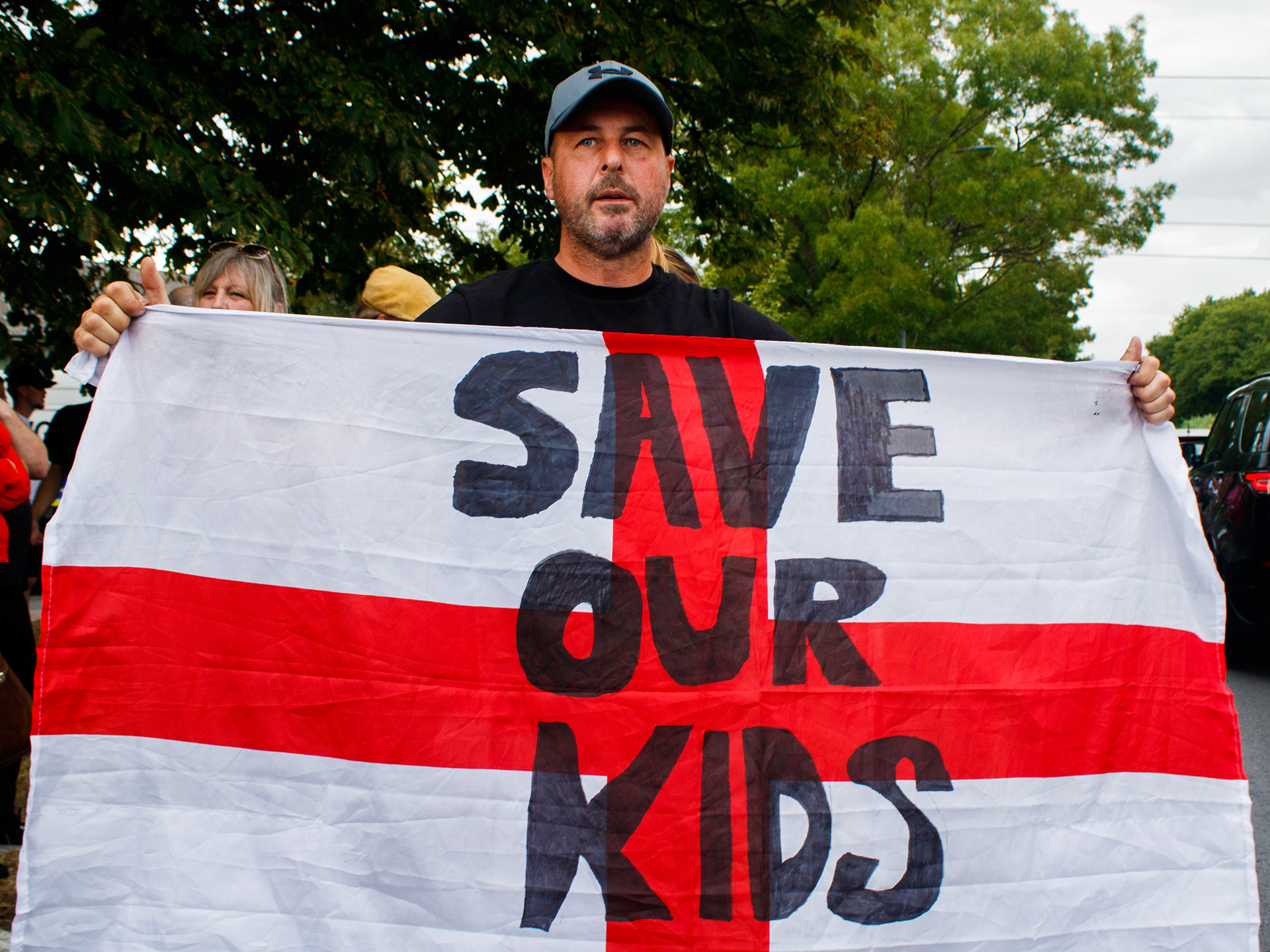 July 17th, 2025 - A man holds an England flag with "save our kids" written on it 