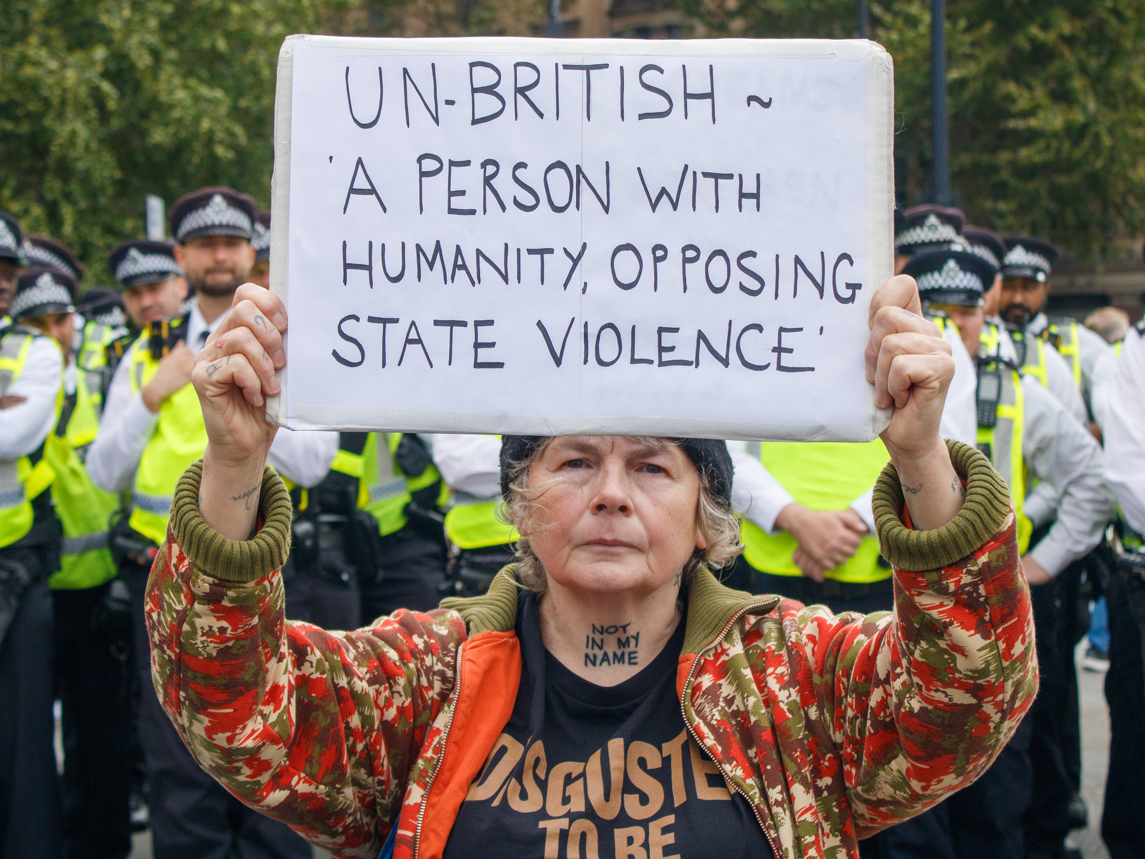 October 4th, 2025 - A protester stands in front of police holding a placard