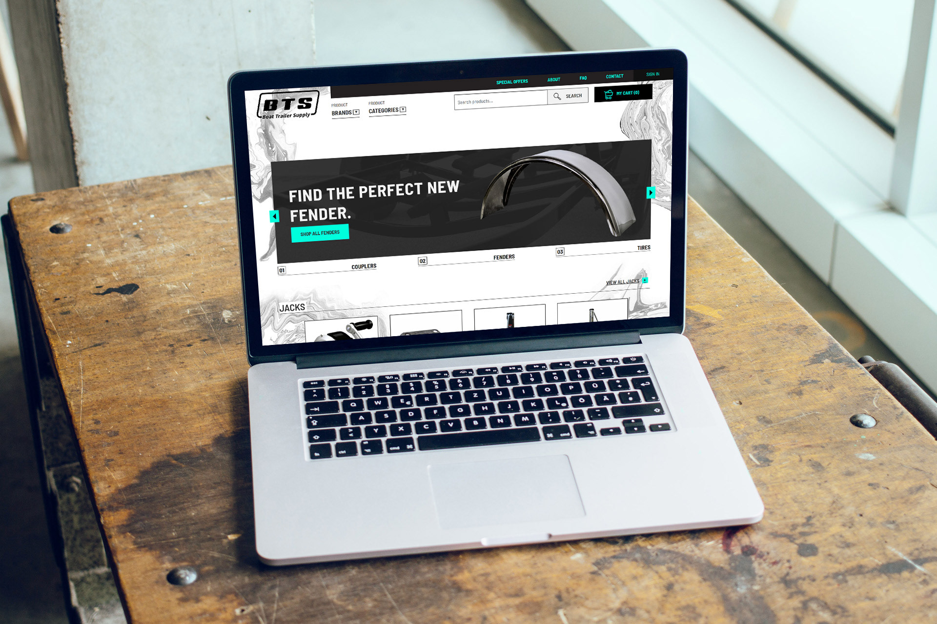 Boat Trailer Supply homepage on a laptop computer on a worn workshop table.