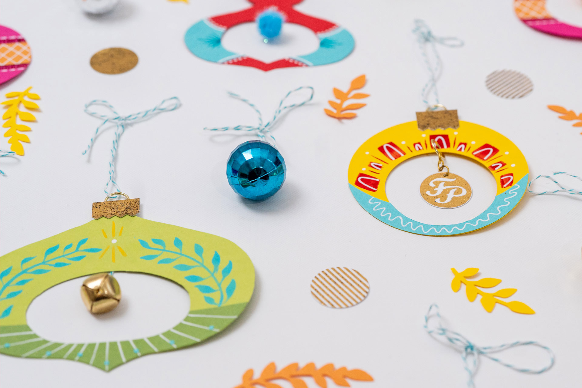 A detail shot of vintage-styled paper ornaments, taken from a low angle on a white background.