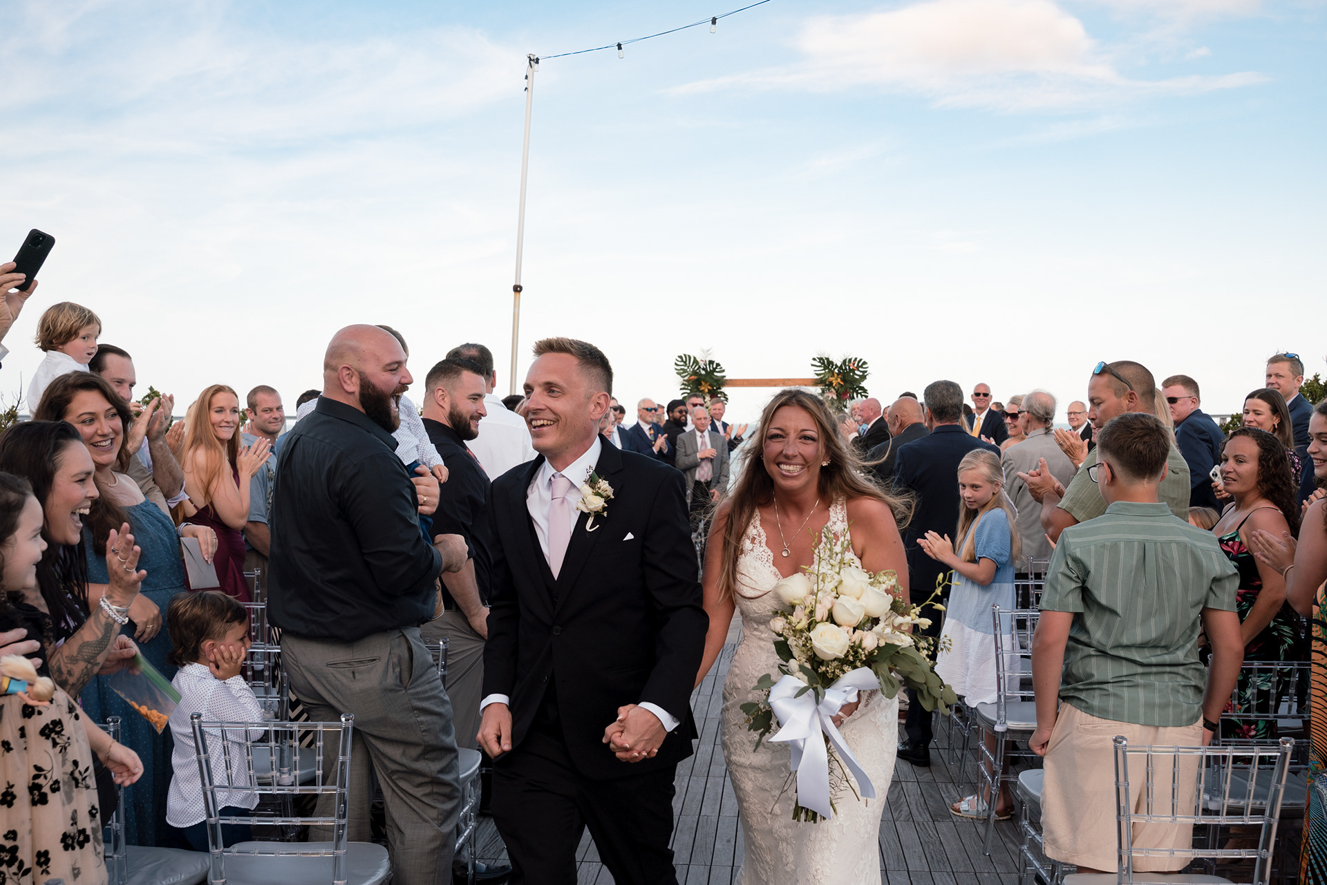 Groom walking into the ceremony with guests watching at Hard Rock Hotel Daytona Beach.