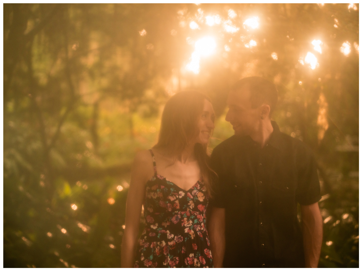 Couple walking through bright golden backlight during a rainy photo session at Washington Oaks Gardens.