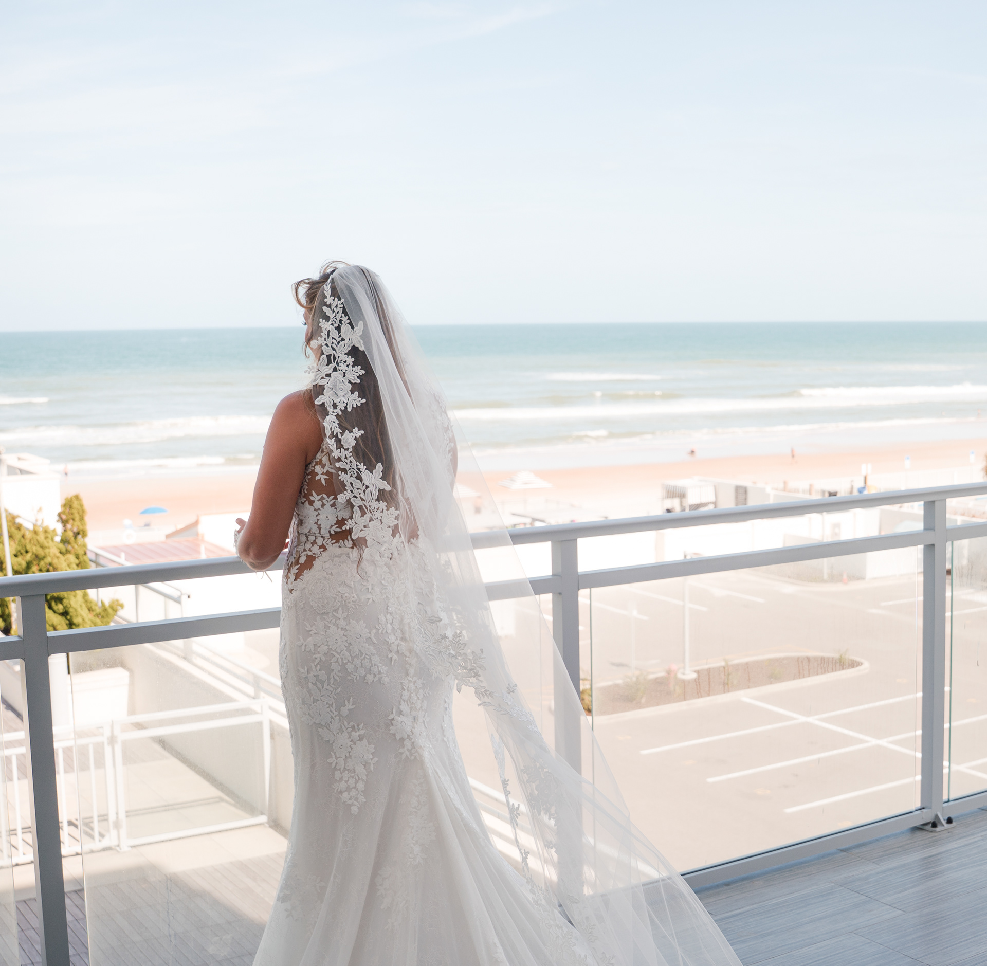 Bride overlooking the ocean from a balcony at Hard Rock Hotel in Daytona Beach, FL.