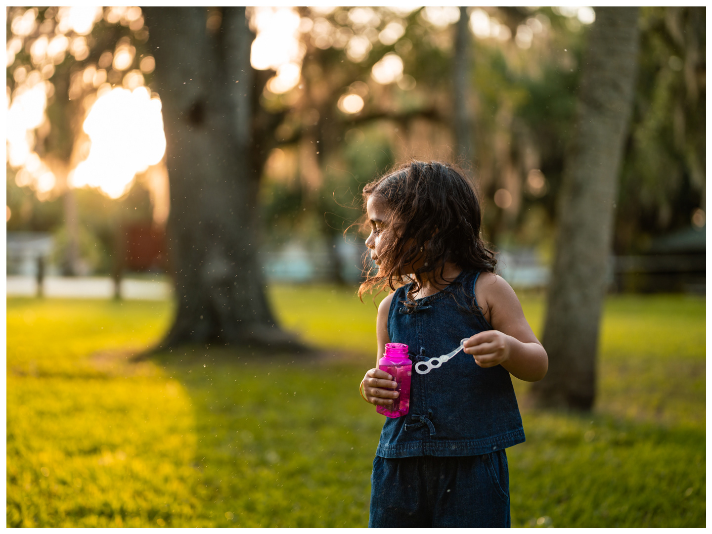 Child playing with bubbles during outdoor family photo session in Port Orange