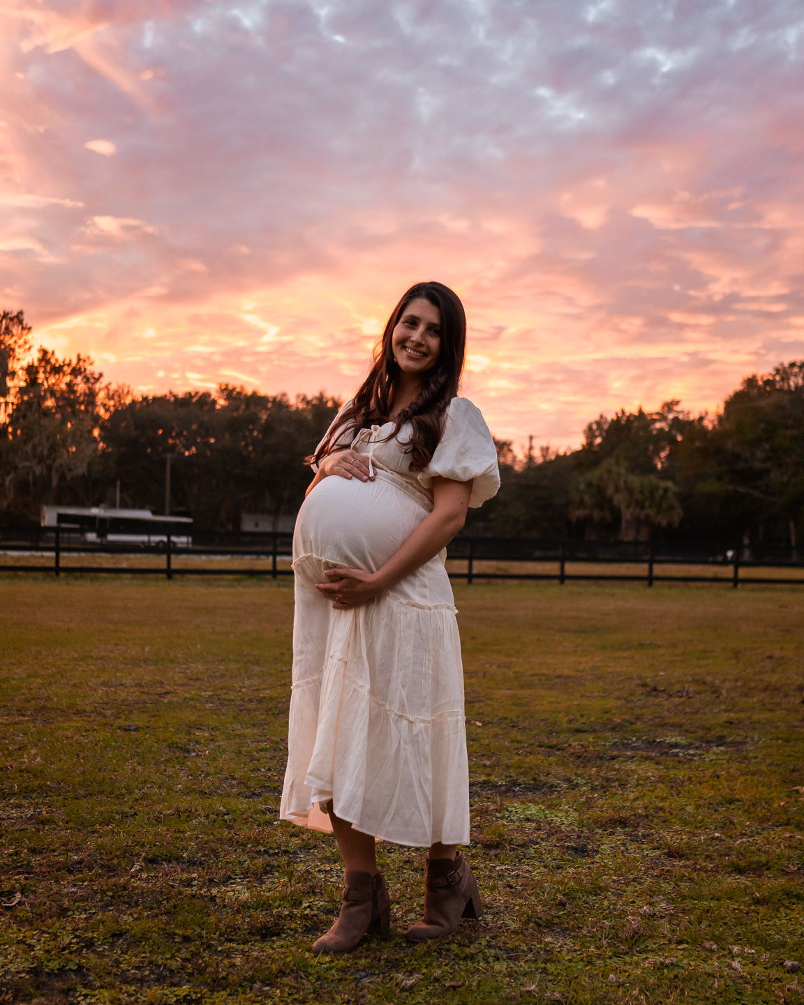 Pregnant mother in white dress during outdoor maternity photos in Florida