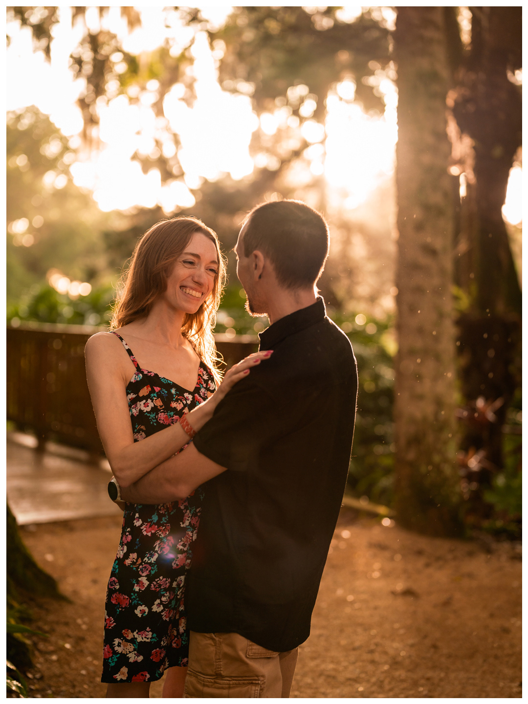 Couple smiling at each other in warm evening light during a Washington Oaks Gardens photo session.